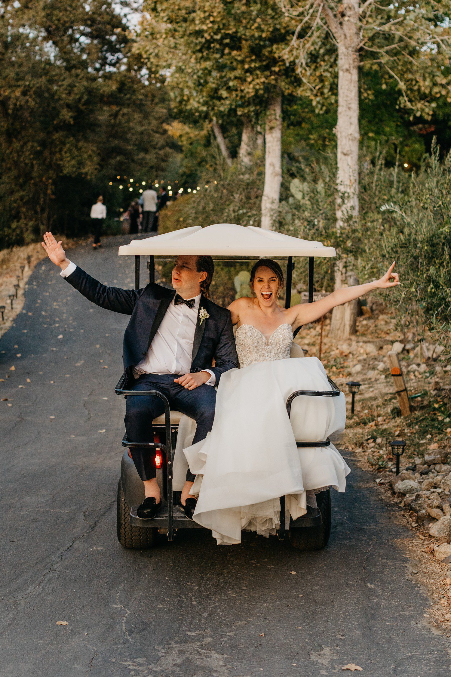 Bride and groom riding golf cart to wedding reception 
