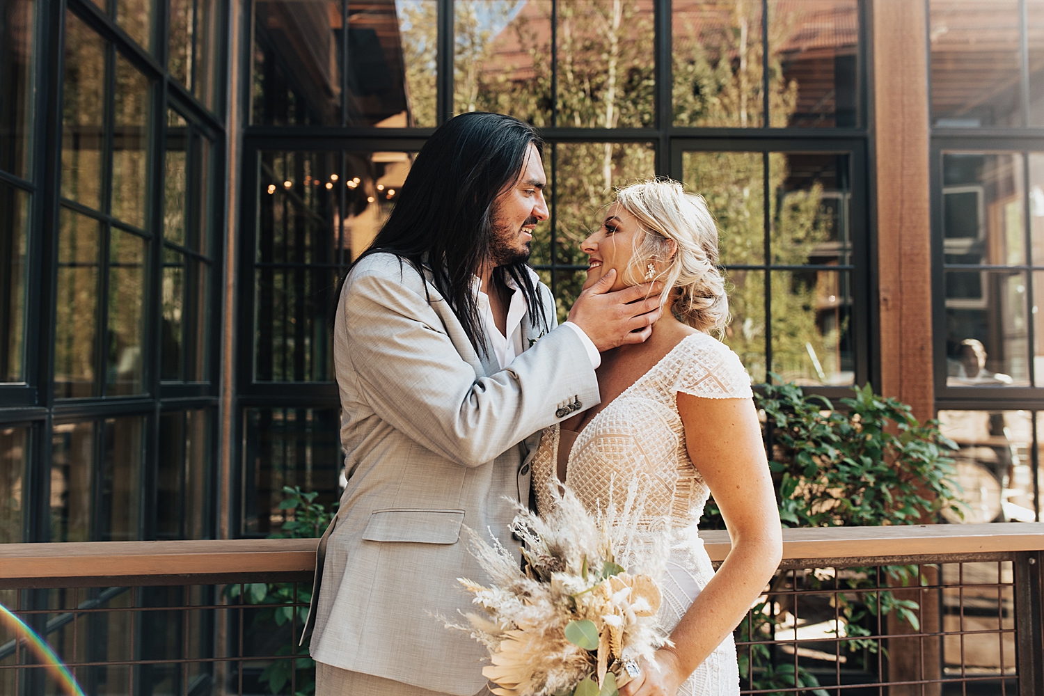 couple share a sweet moment of embrace in front of windows by Destination wedding photographer 