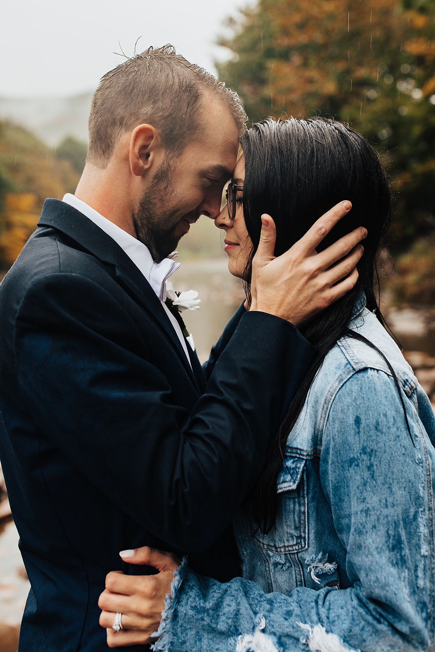 man holds wife's face close for rainy autumnal intimate day