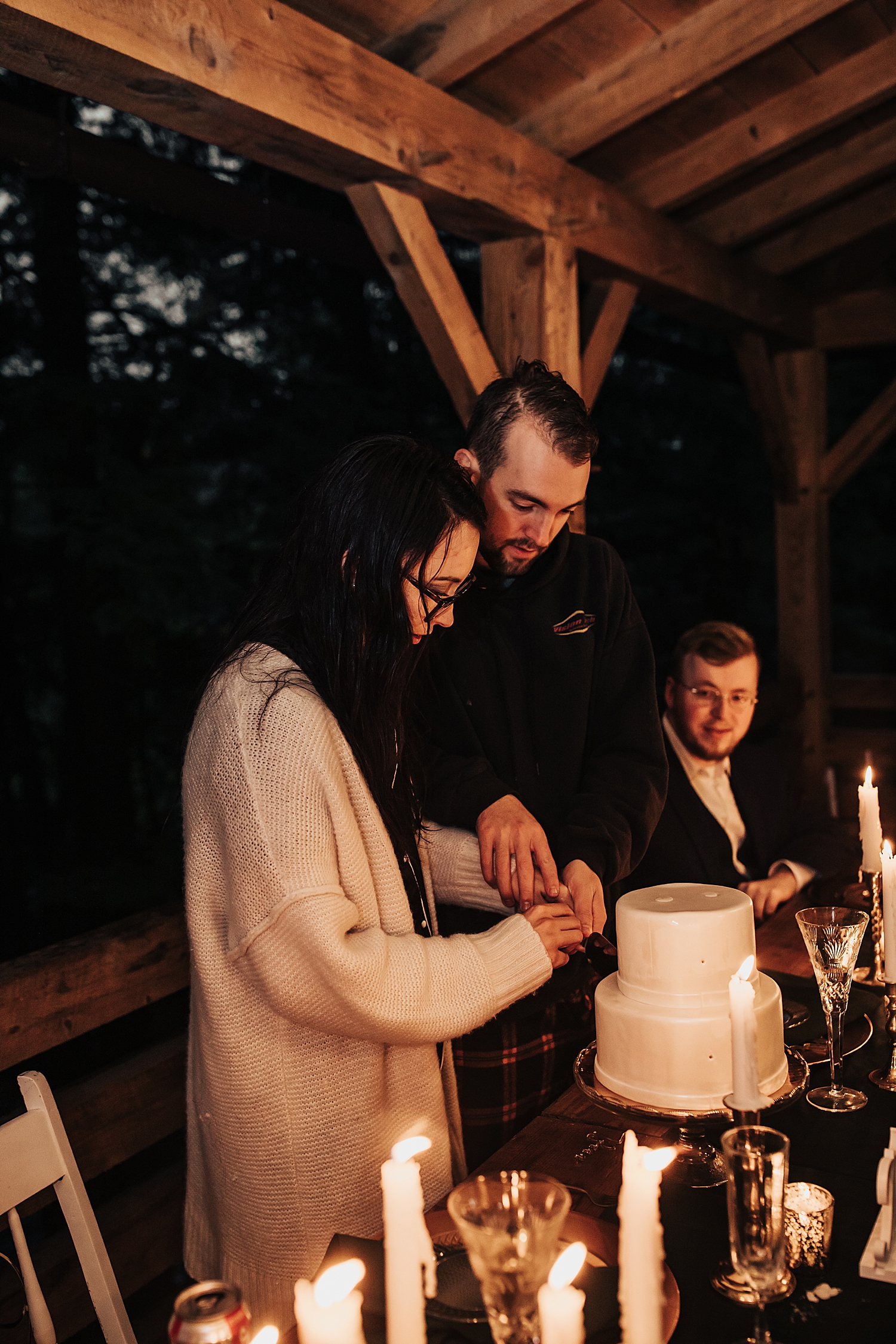 husband and wife cut white cake by Nicole Aston Photography