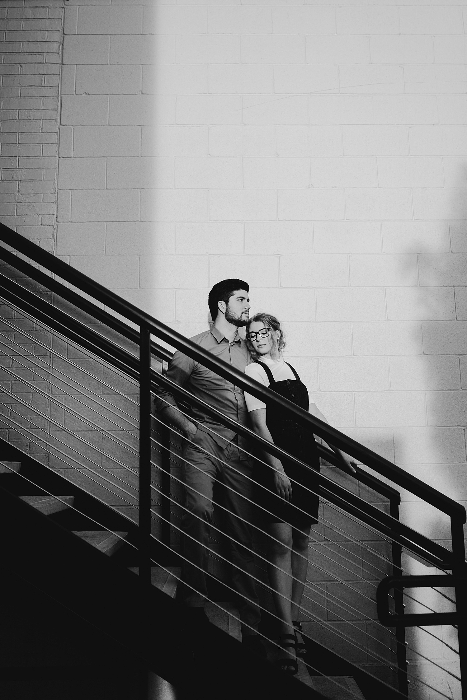 woman leans back against her husband on staircase by Destination Wedding Photographer