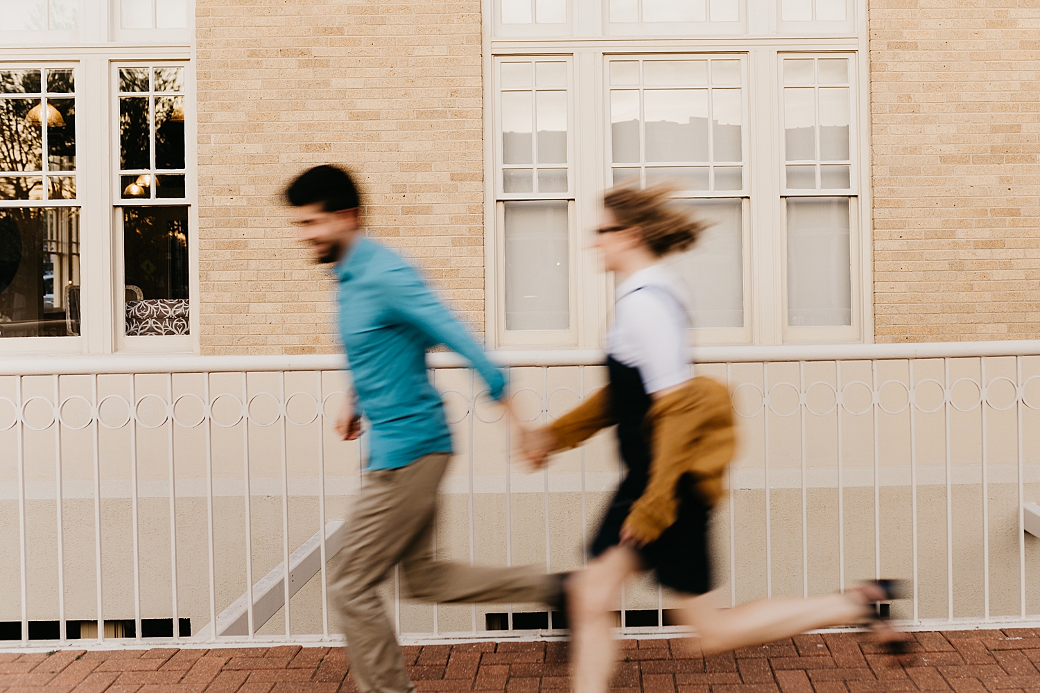 husband and wife running down city sidewalk for Downtown DFW Couples Session