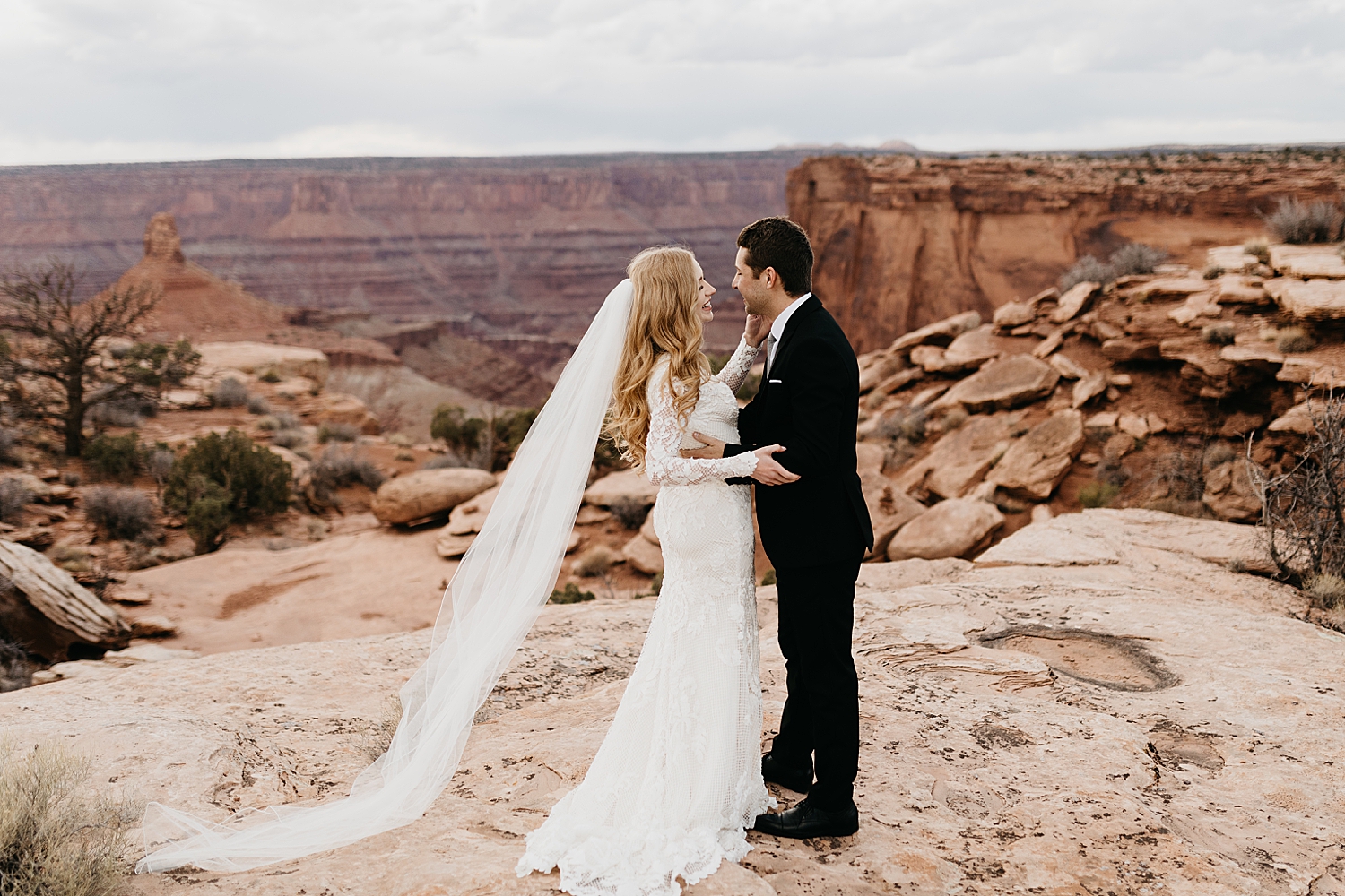 couple embraces near canyon during Moab Dead Horse Point Bridal Shoot