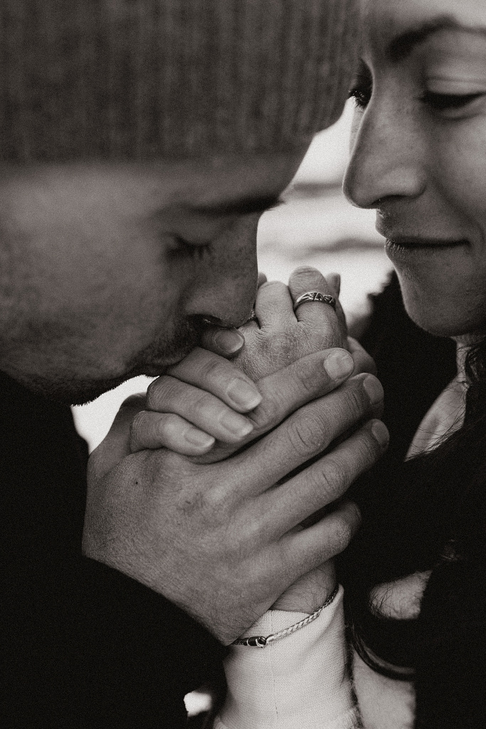 groom kisses bride-to-be's fingers by Destination wedding photographer