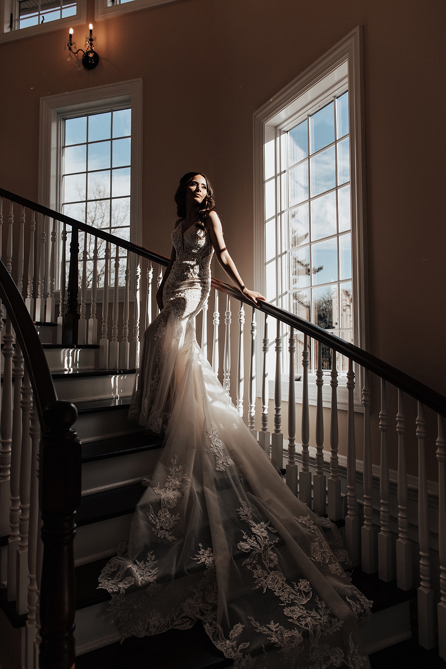 woman in bridal gown leans on dramatic staircase by Destination elopement photographer