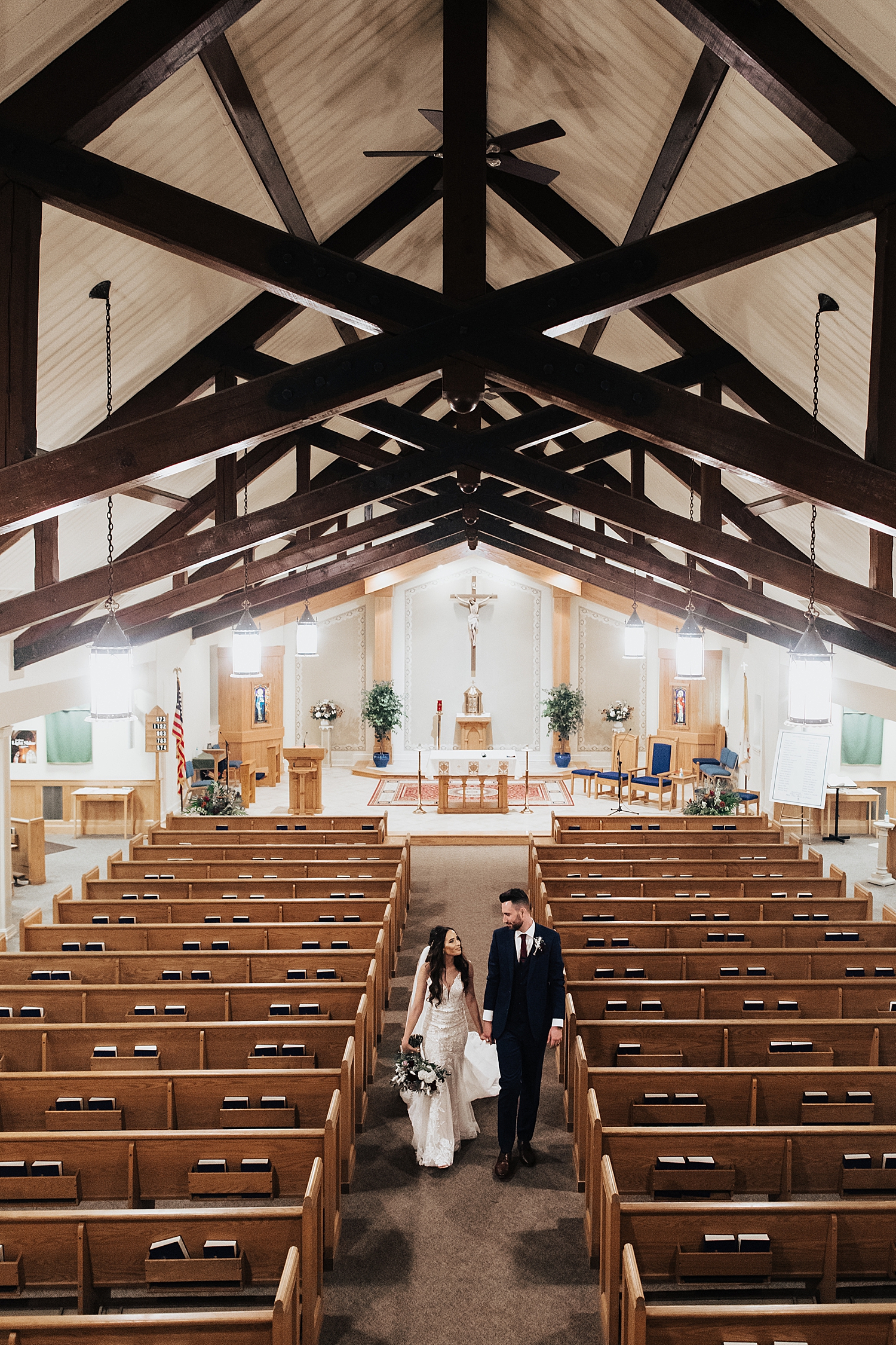 newlyweds walk down church aisle by Destination elopement photographer