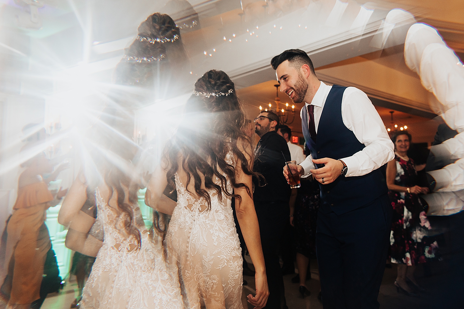 newlyweds dance under big lights on floor by Destination elopement photographer