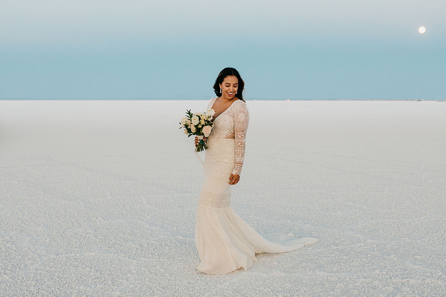 bride looks over her shoulder at the Bonneville Salt Flats by Nicole Aston Photography