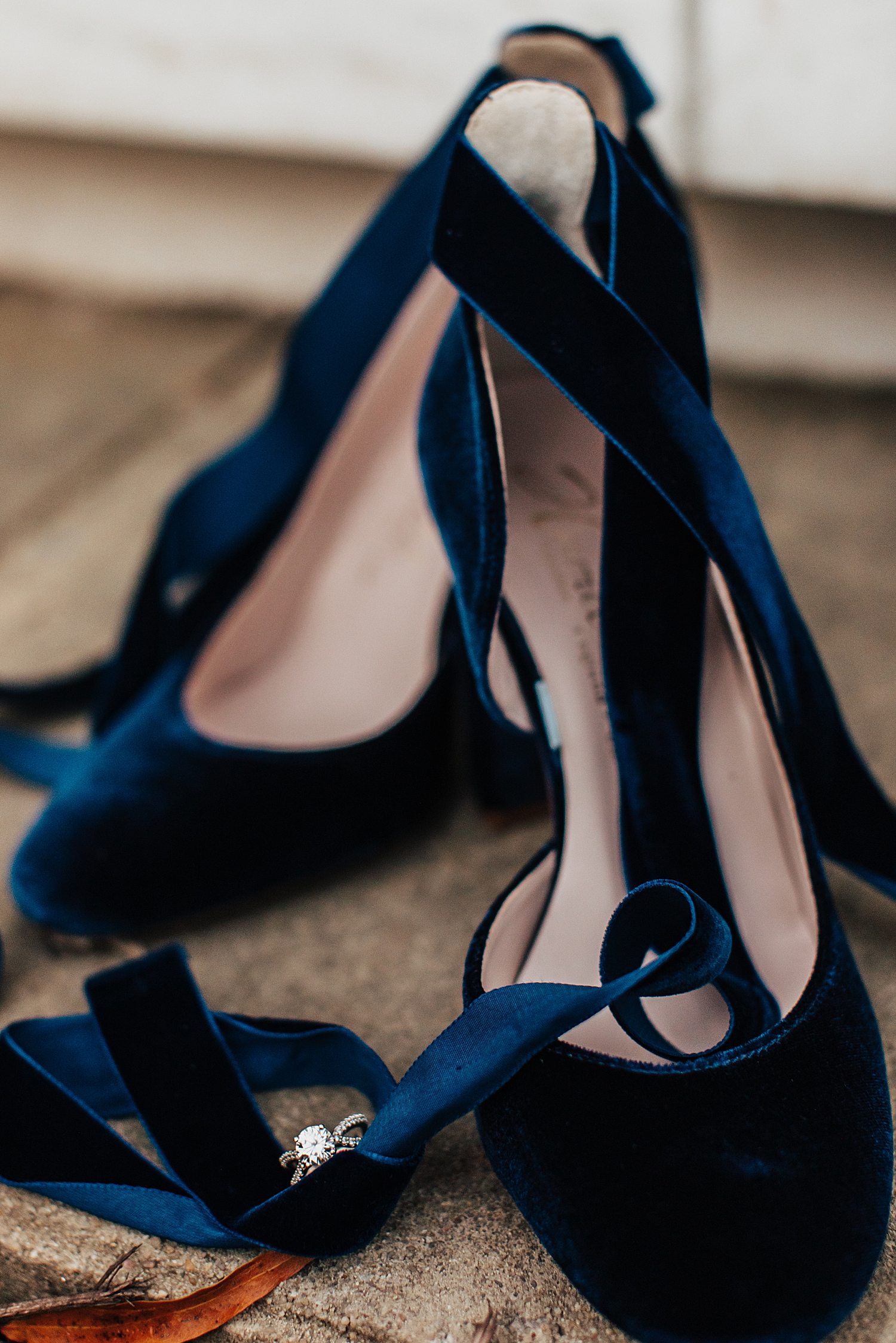 diamond ring nestled in blue velvet heels by Nicole Aston Photography