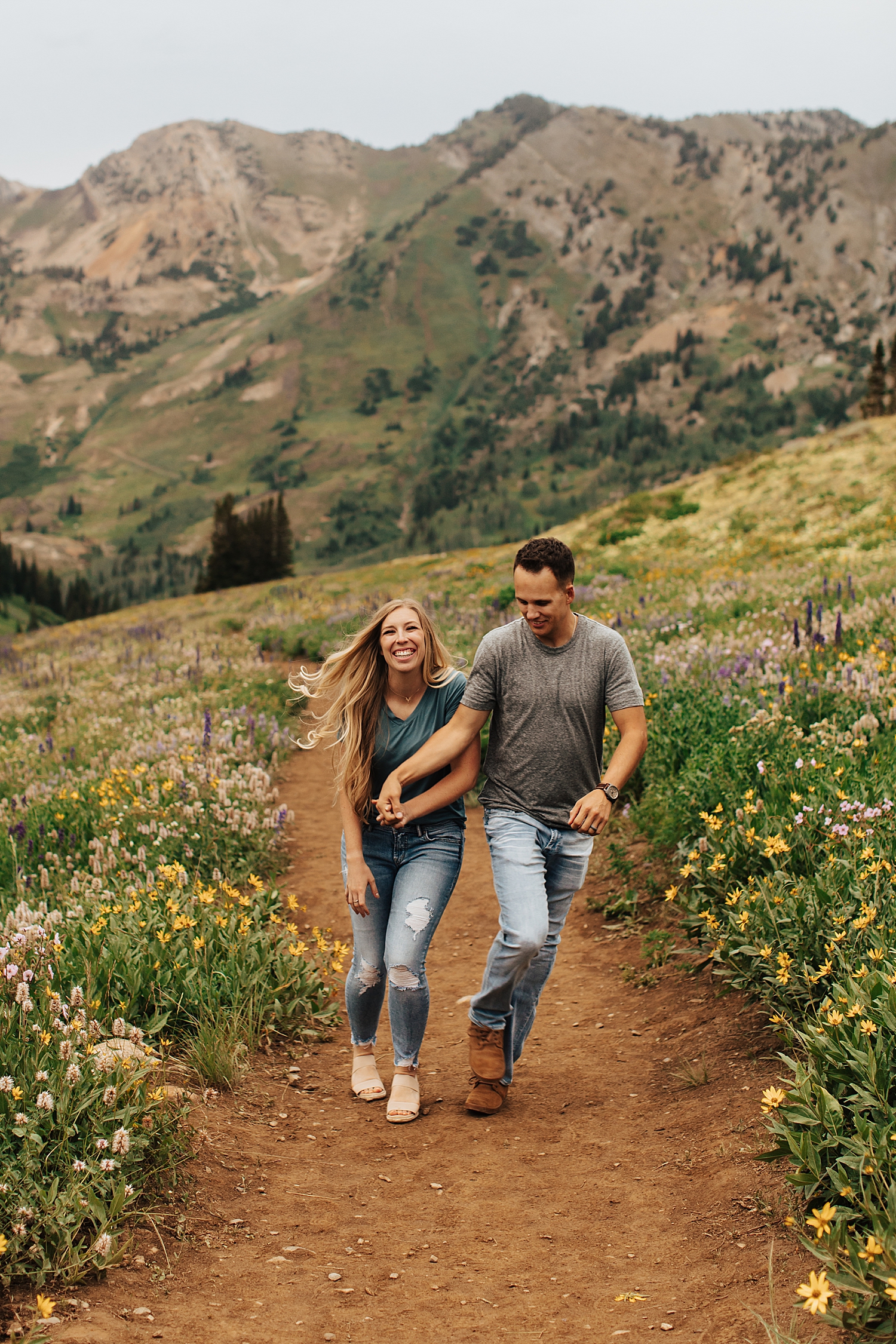 couple runs up pathway on mountain trail by Destination wedding photographer