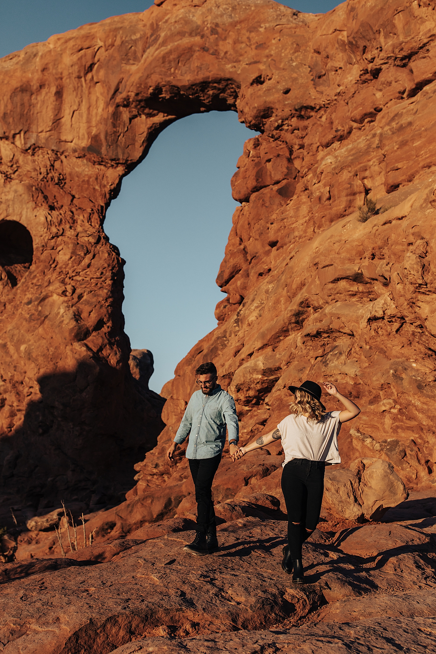 engaged couple walks on a hike together in sunset by Nicole Aston Photography