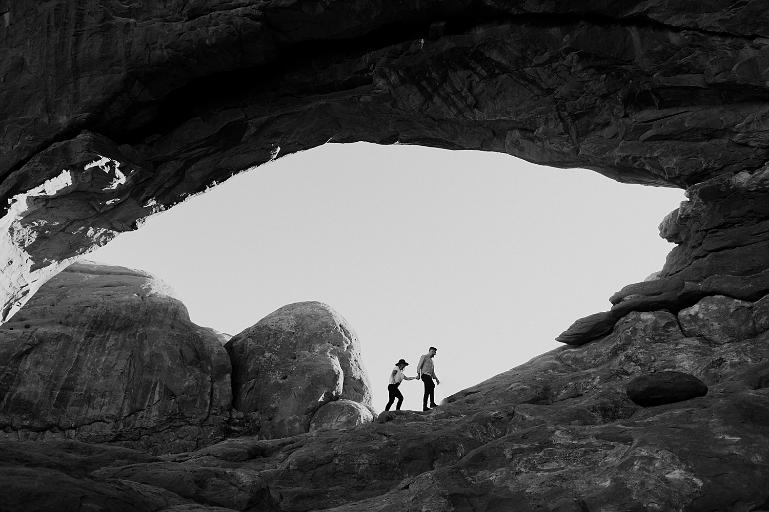 man and woman walk up a hike together at sunset by Destination wedding photographer