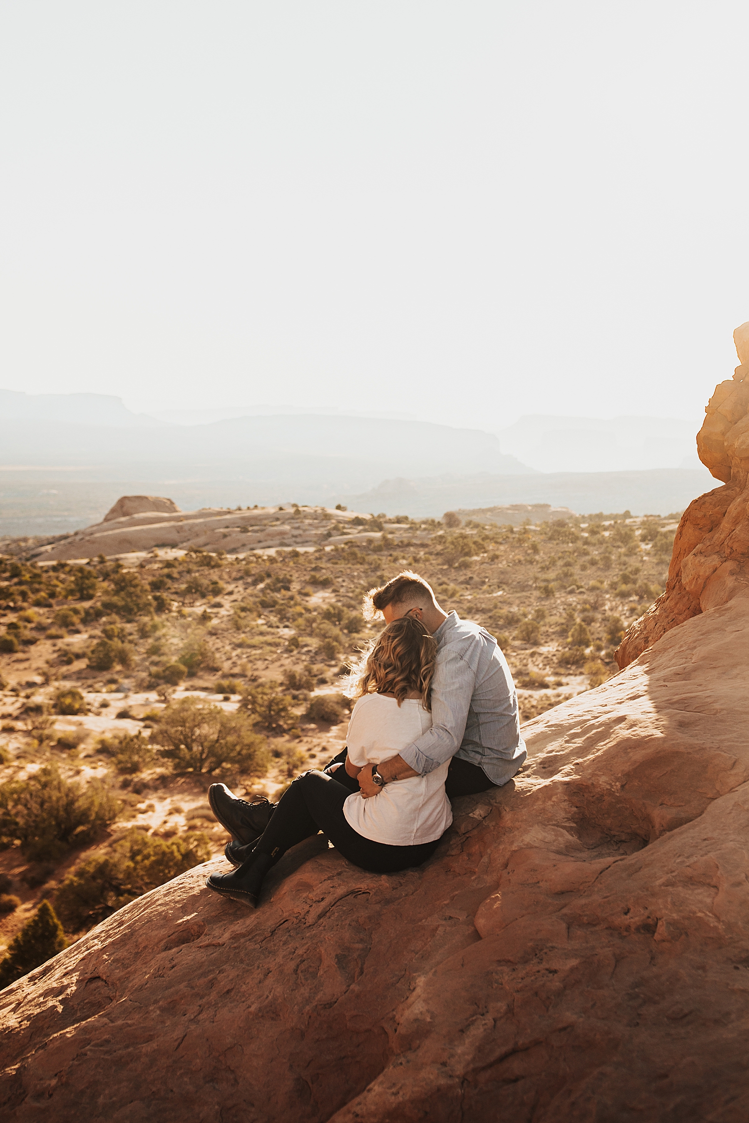 man snuggles close to his girl on overlook during sunset by Nicole Aston Photography