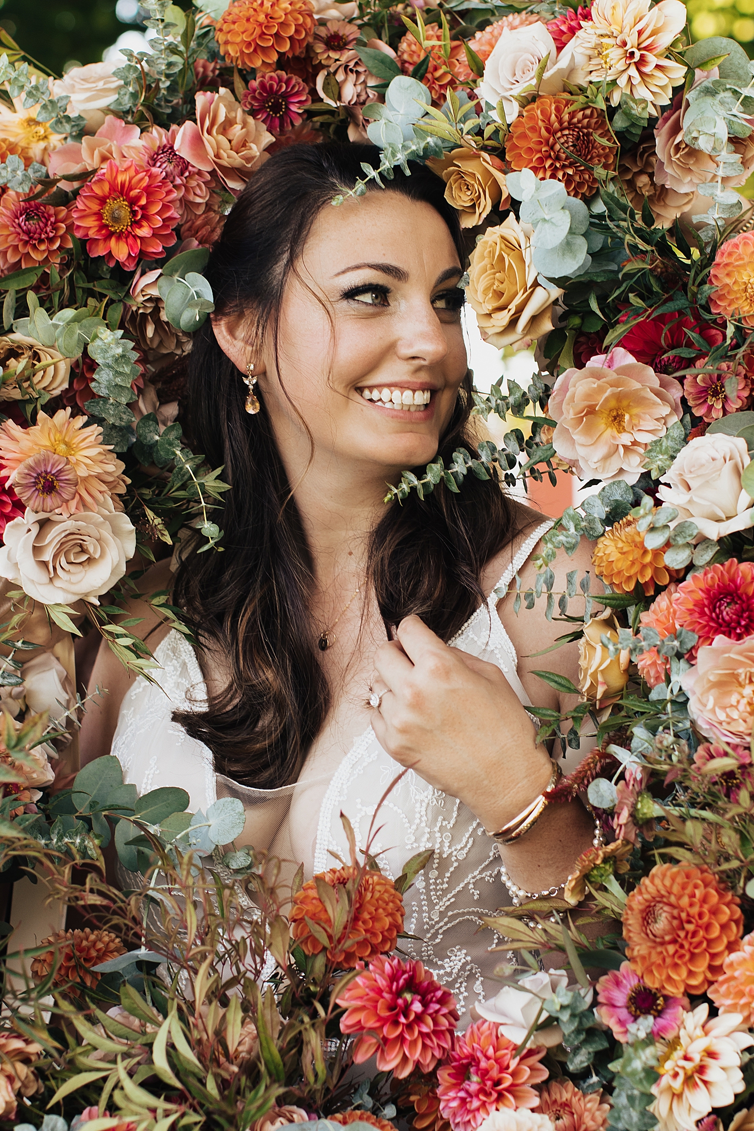 brunette is surrounded by flowers by bridesmaids at The Finger Lakes