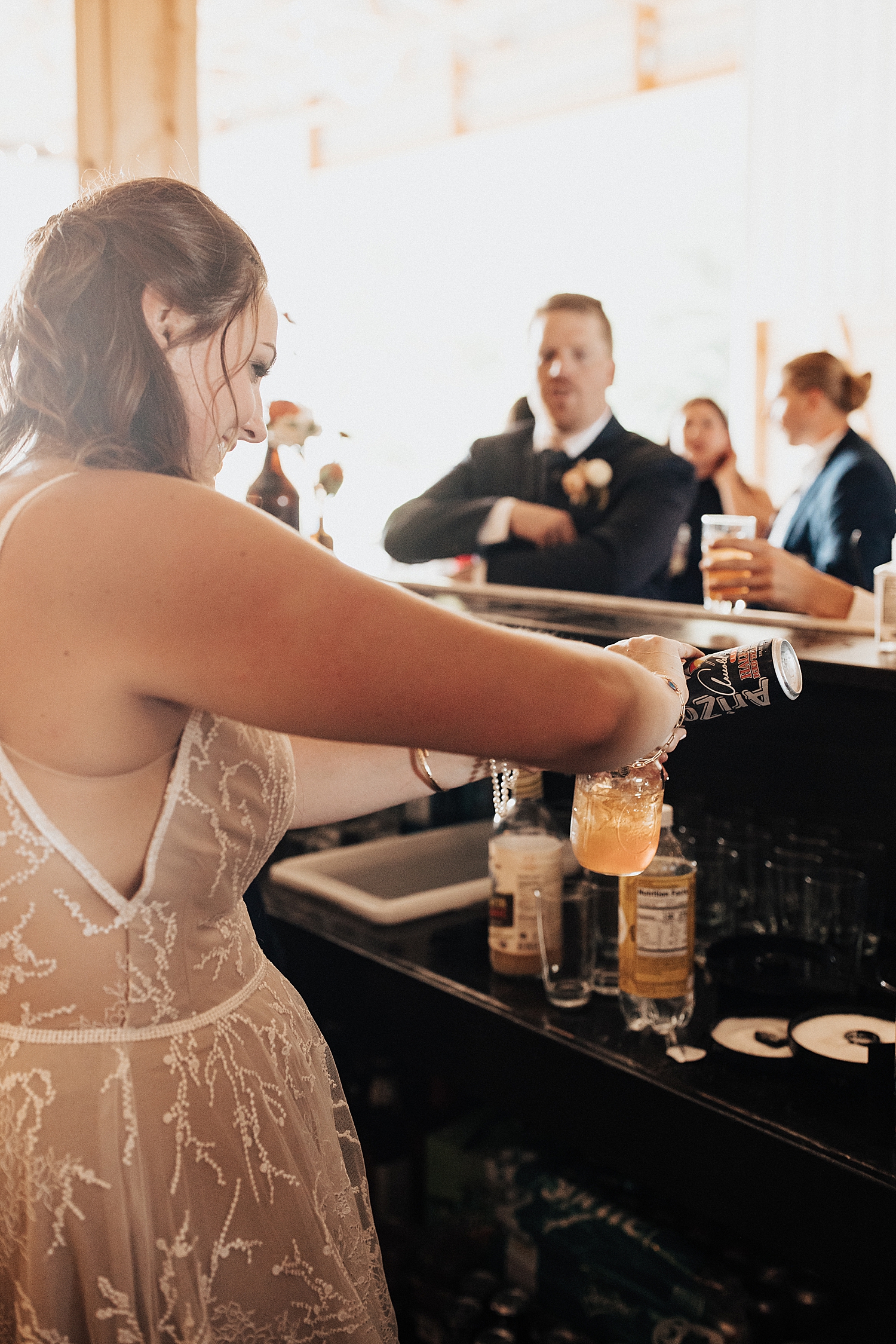 bride steps behind the bar to make cocktails in The Finger Lakes