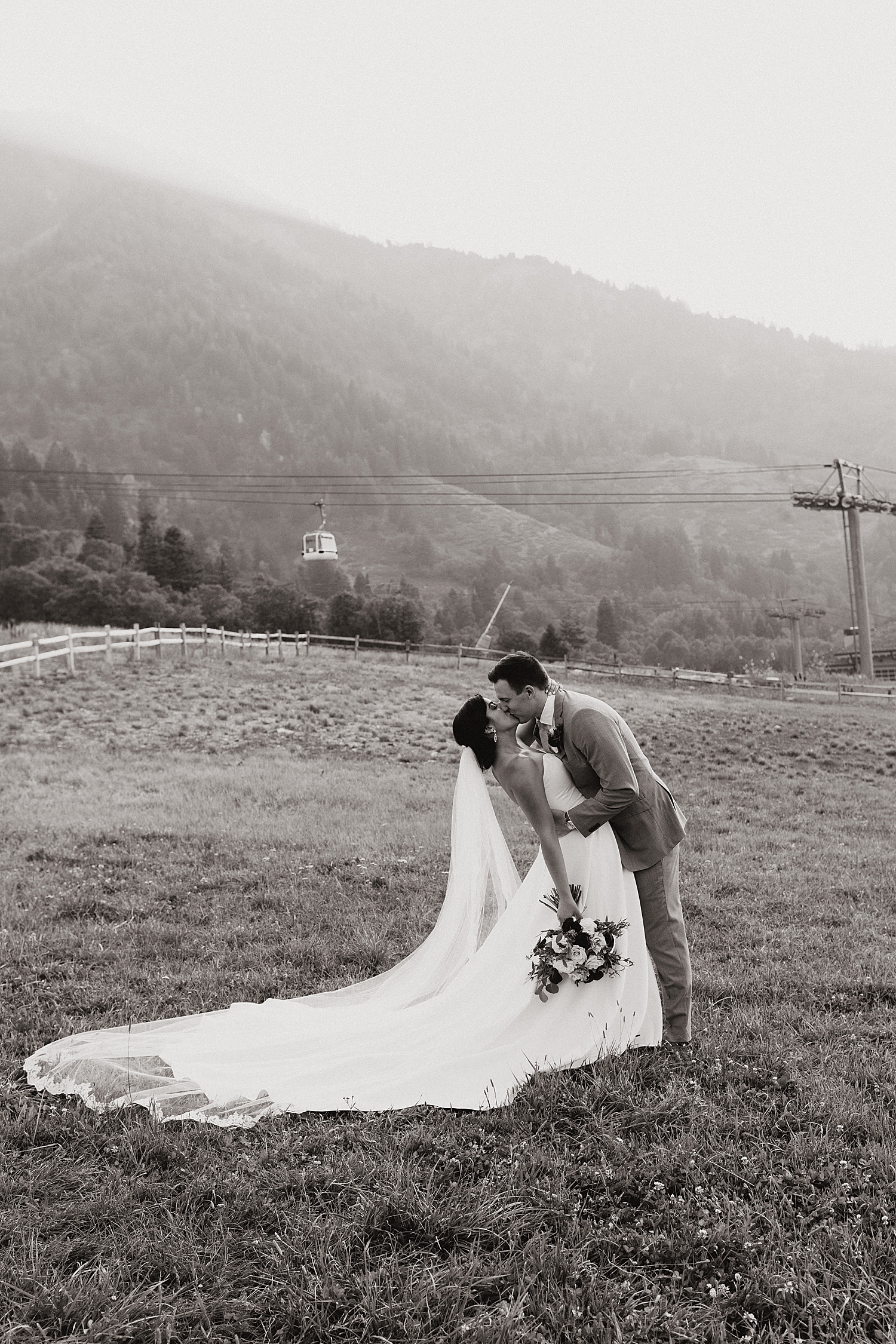 man leans in to kiss his woman on the mountainside at Snowbasin