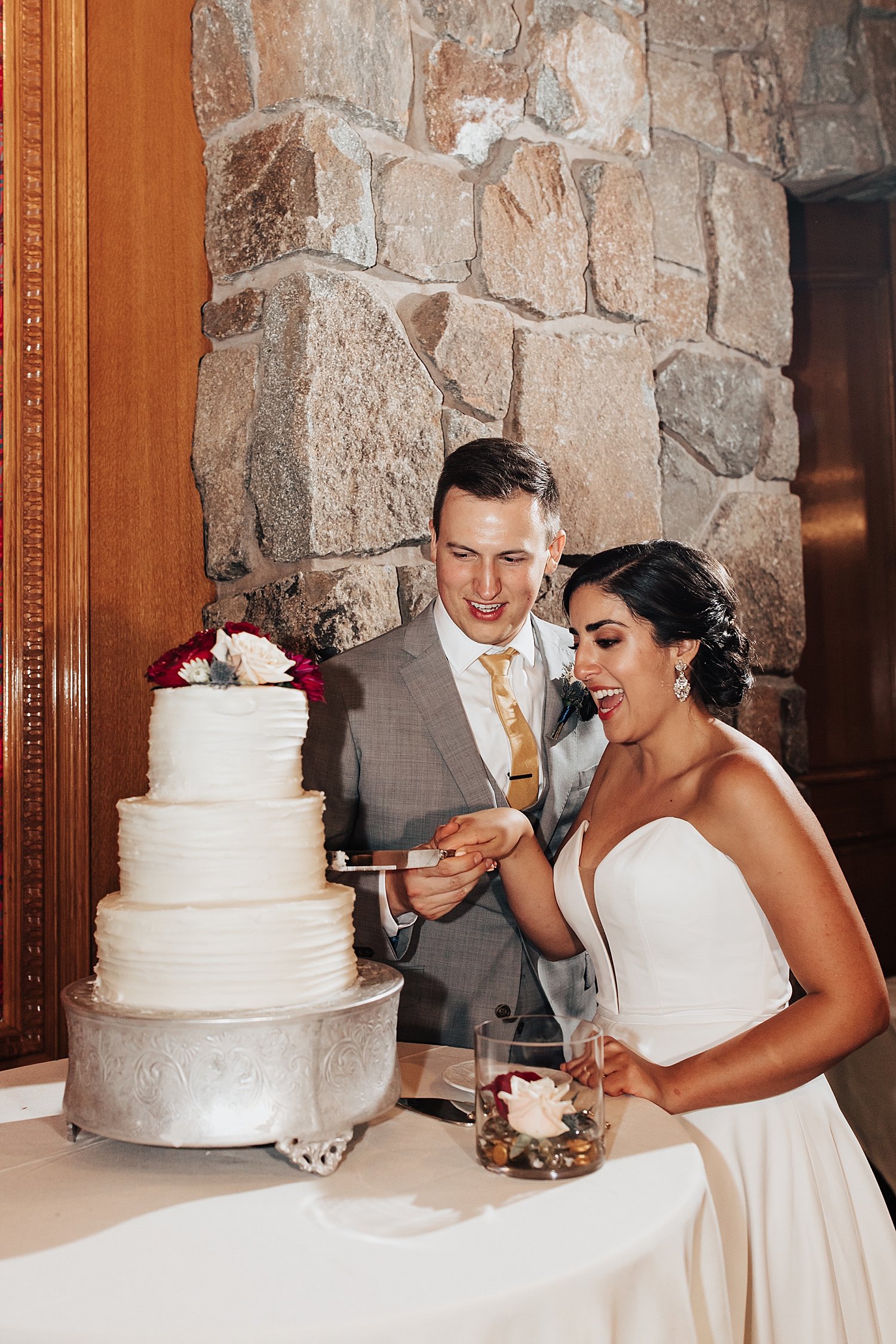 newlyweds cut the cake at reception by Destination wedding photographer