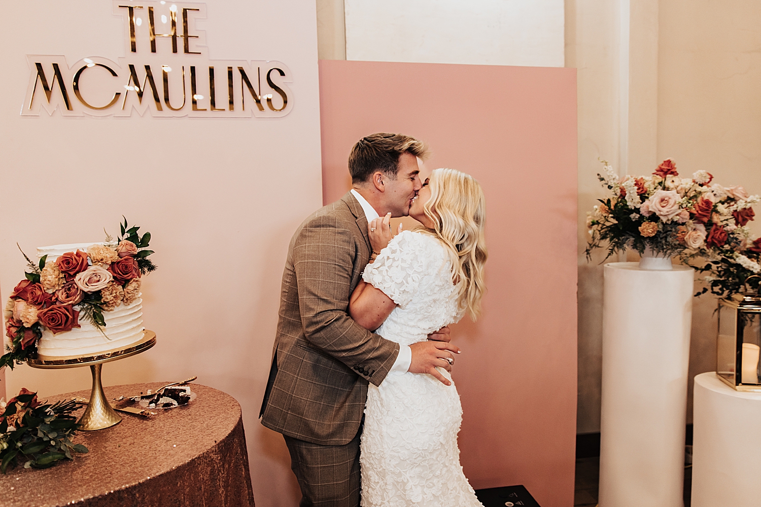 newlyweds kiss after cutting cake by Destination wedding photographer
