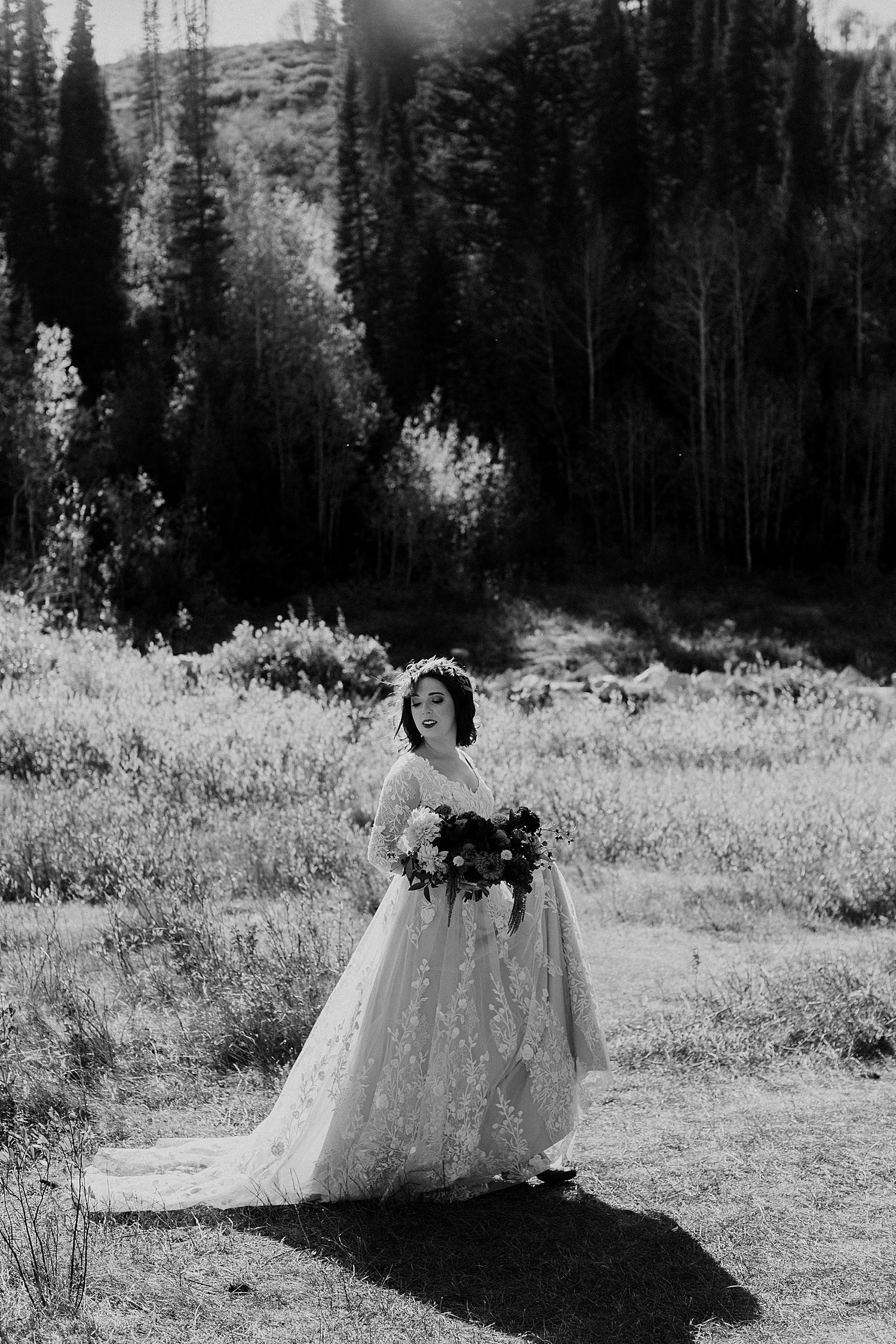 bride walks through field with her flowers in hand by Destination wedding photographer