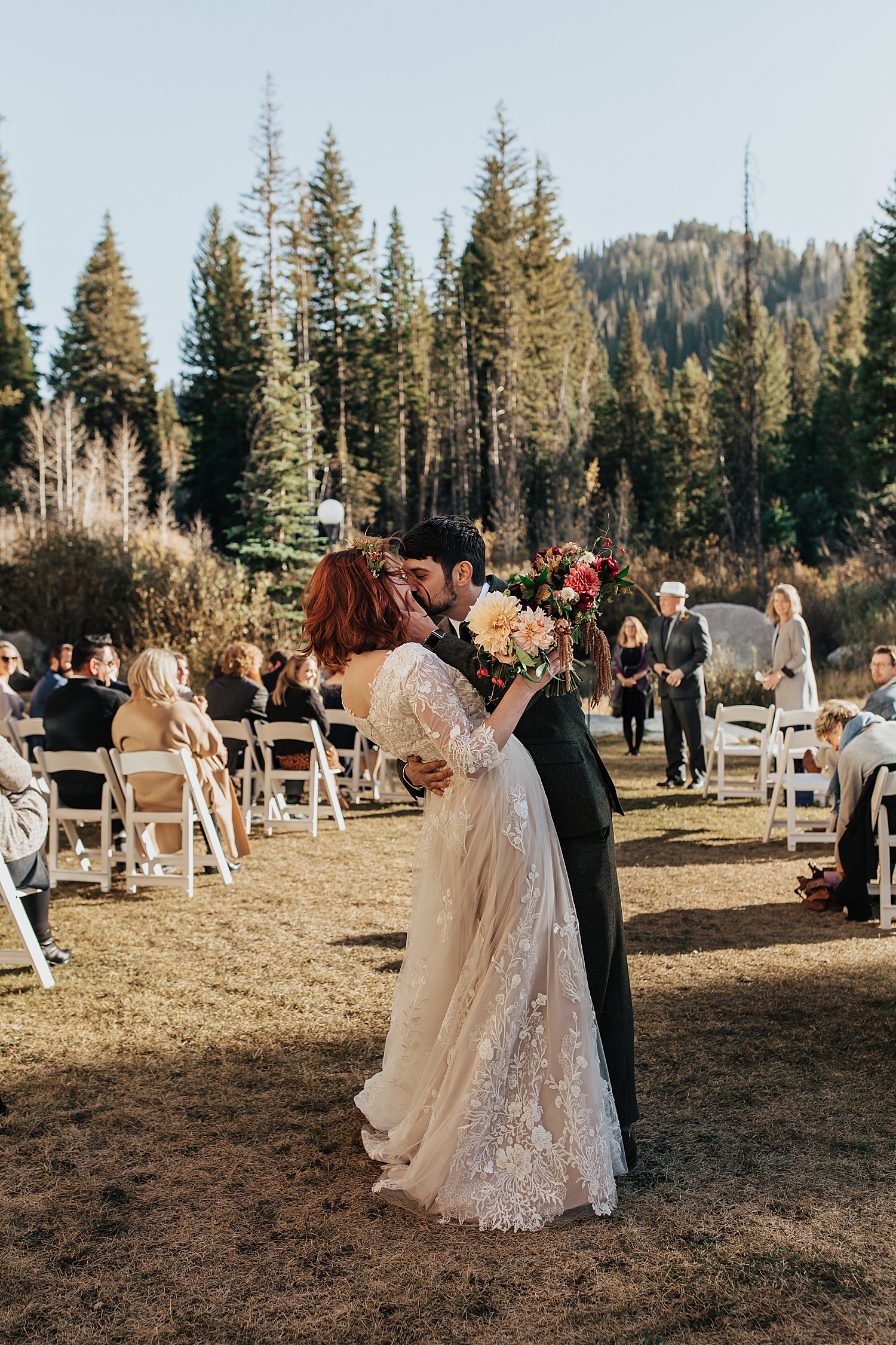 man dips new wife for a kiss at end of aisle outside in Utah by Nicole Aston photography 