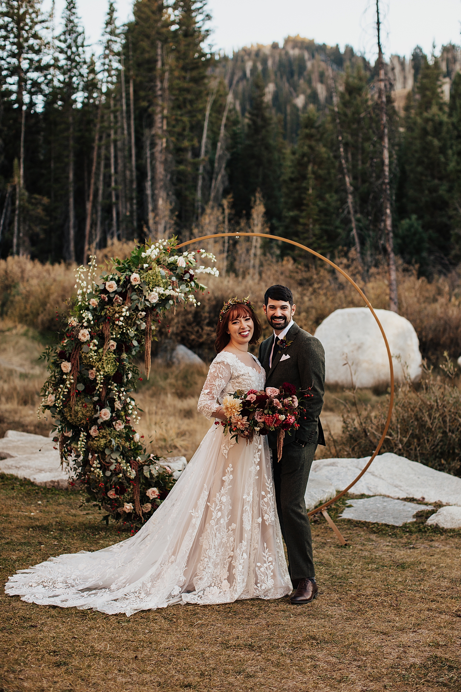 newlyweds stand under circle arch outside at Solitude Resort in Park City