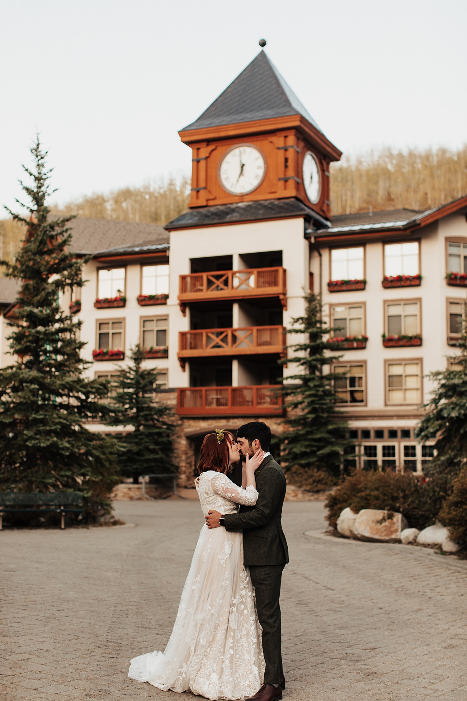 newlyweds kiss in front of old clocktower in Utah by Nicole Aston photography 
