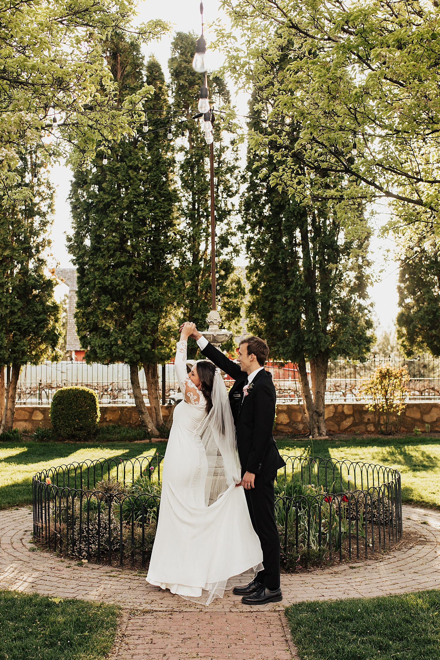 man gives woman twirl in the garden by Nicole Aston Photography