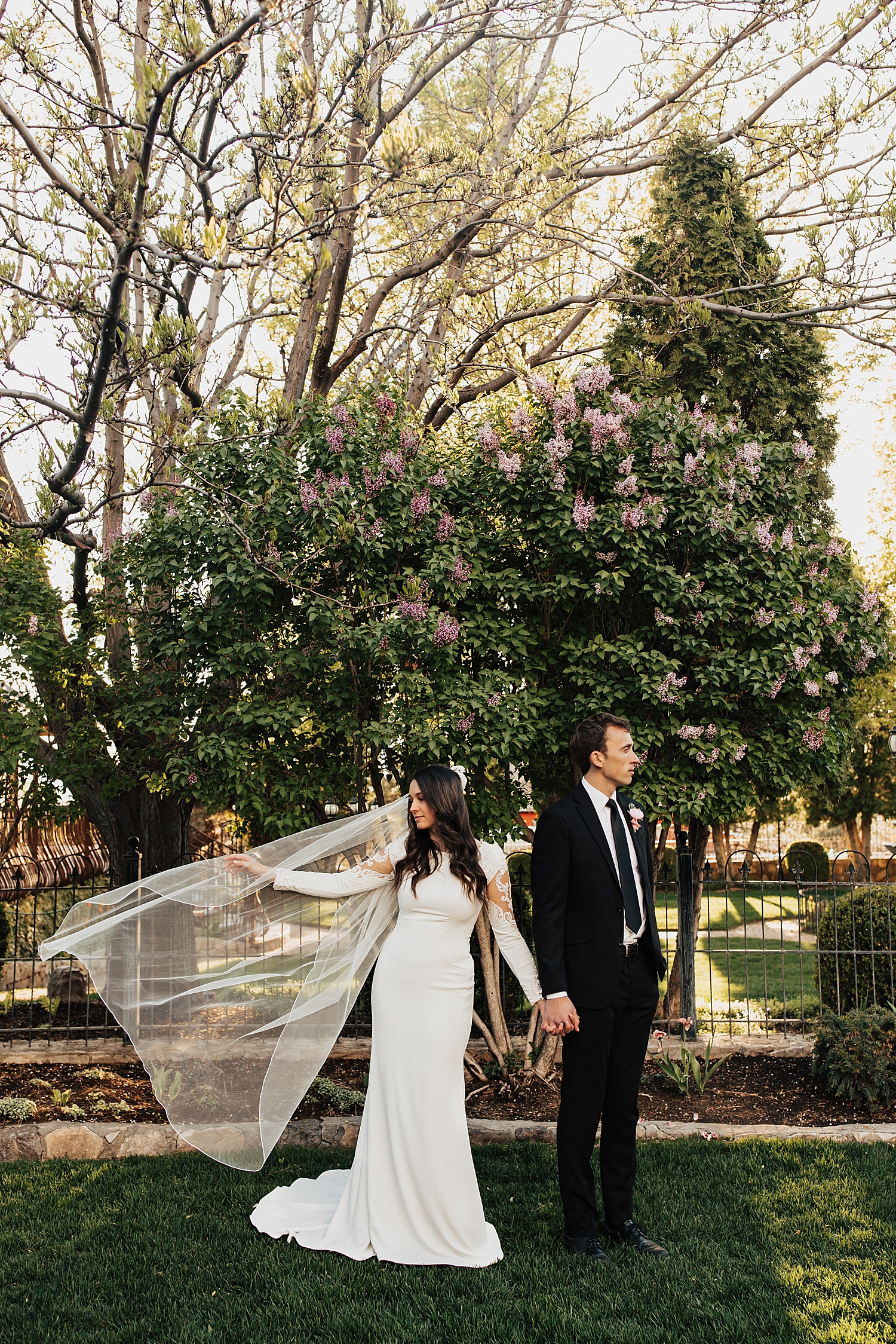bride and groom hold hands and face opposite directions by destination wedding photographer
