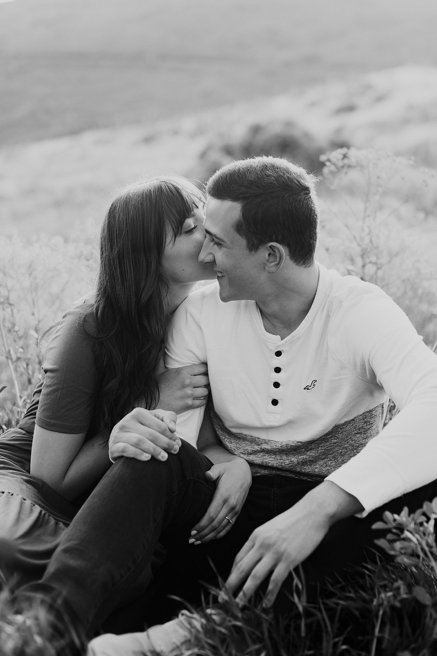 couple sits in wildflower together in Utah by Nicole Aston Photography