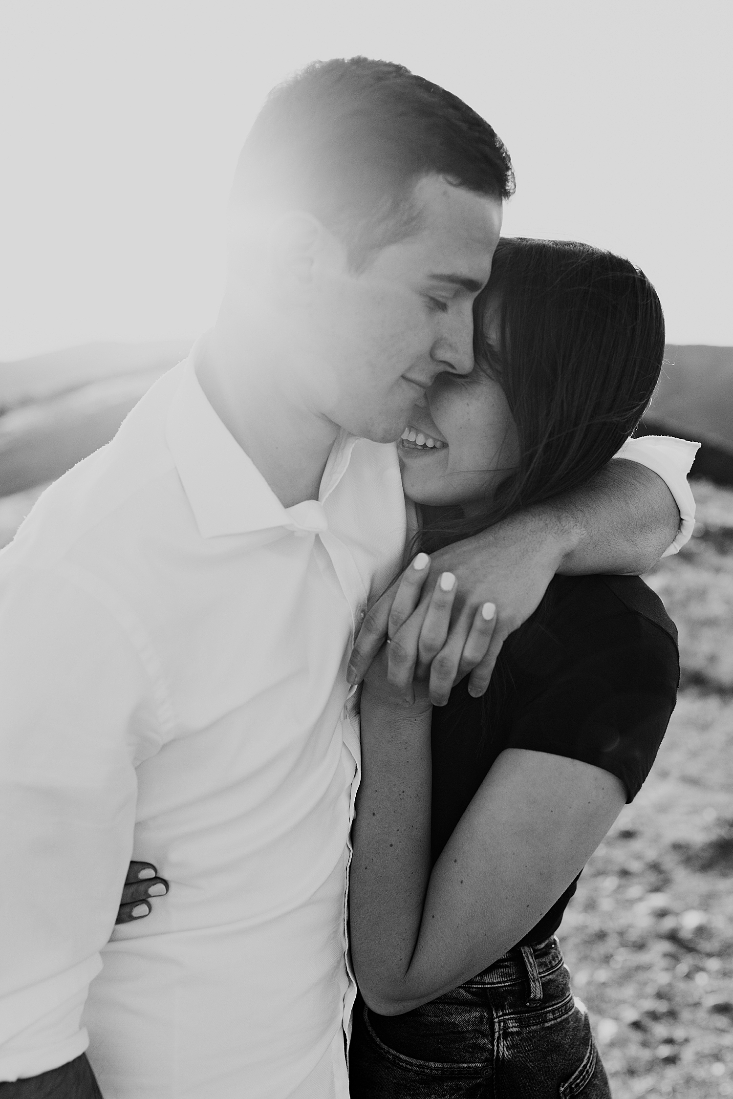 man holds his wife-to-be closely in golden hour by Nicole Aston Photography