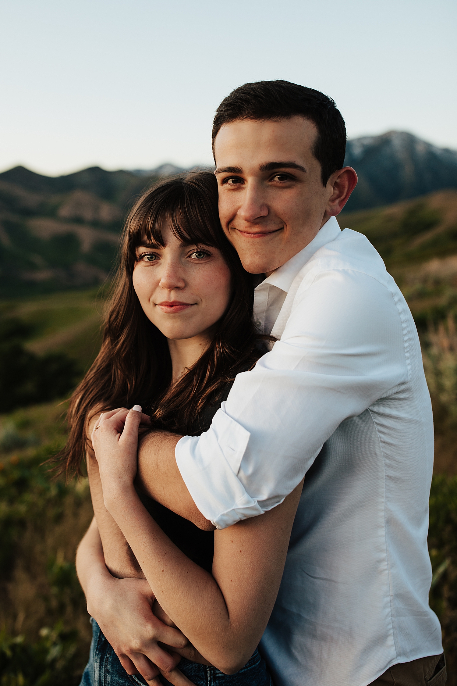 Man hugs his fiance from behind for Salt Lake City foothills session