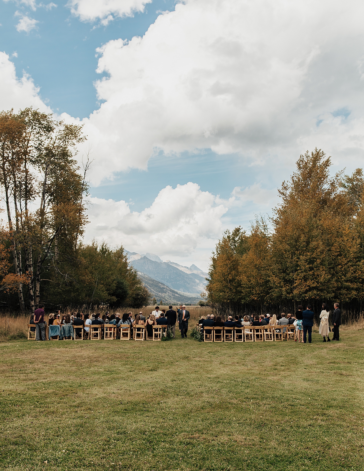 guests sit on lawn in chairs for ceremony by Nicole Aston Photography