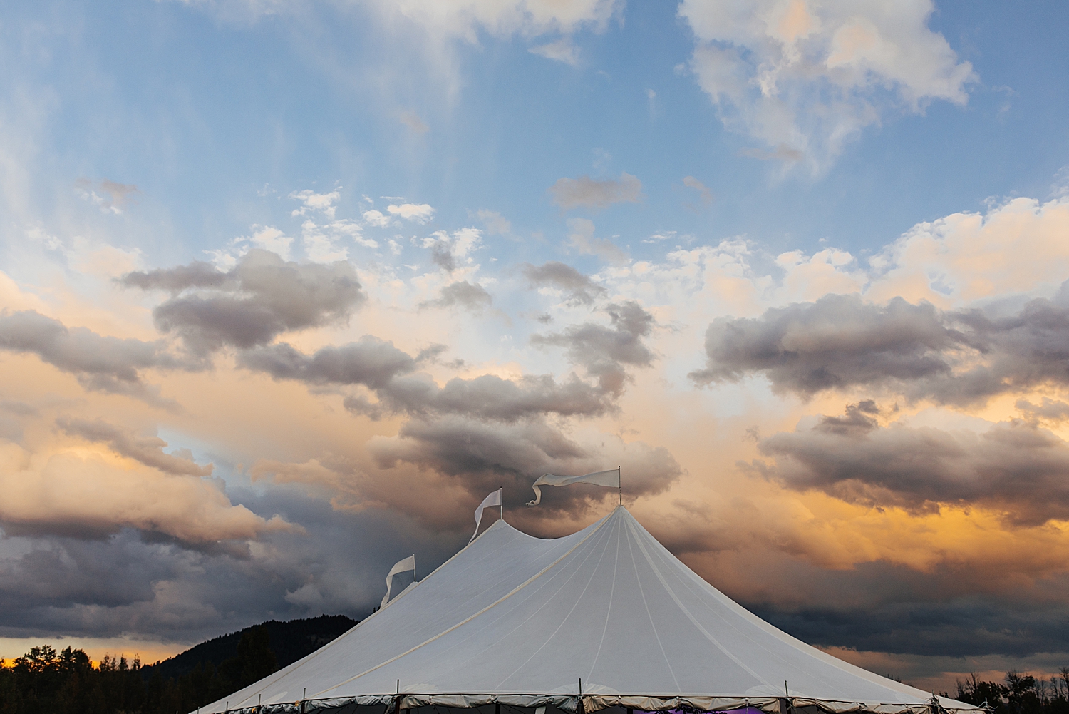 large tent top under Wyoming sunset sky by Destination wedding photographer