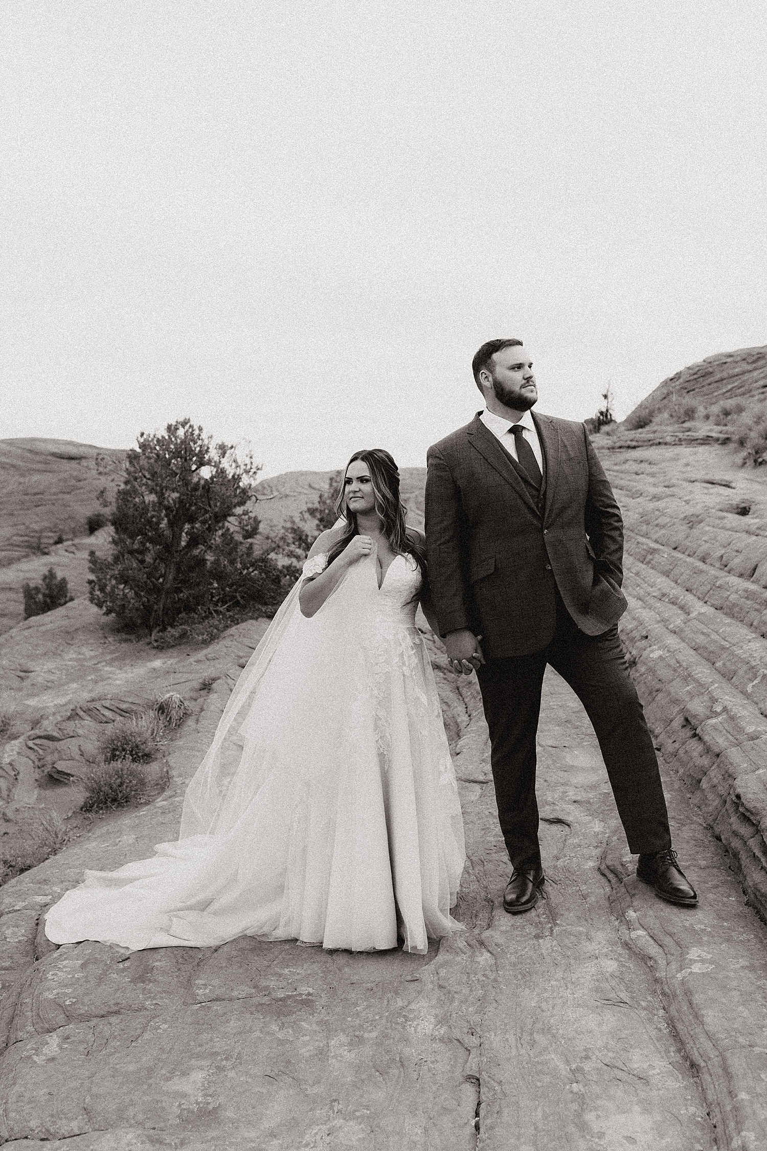 newlyweds stand side by side in desert by Destination wedding photographer