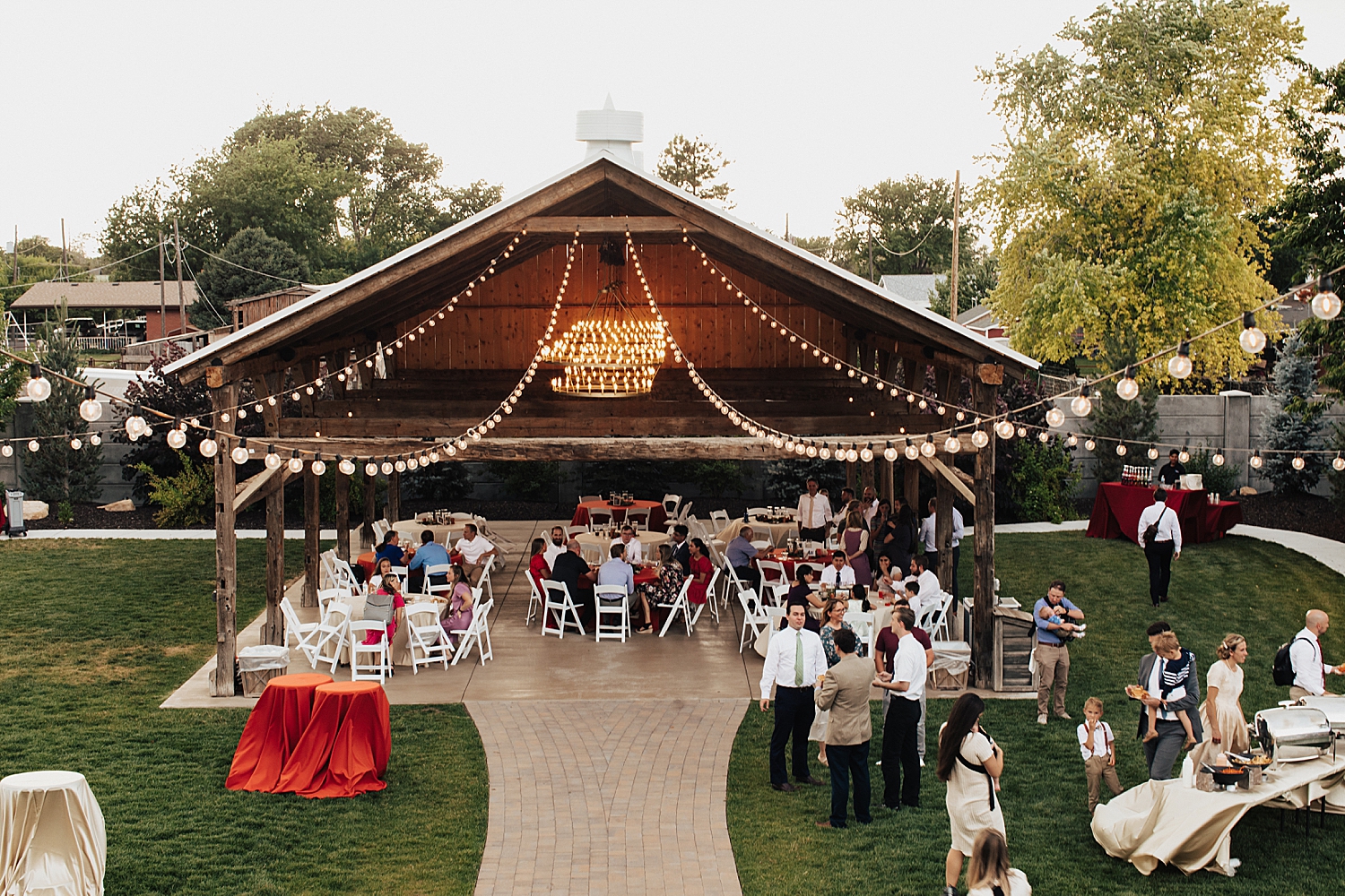 guests eat under outdoor pavilion structure by Destination wedding photographer