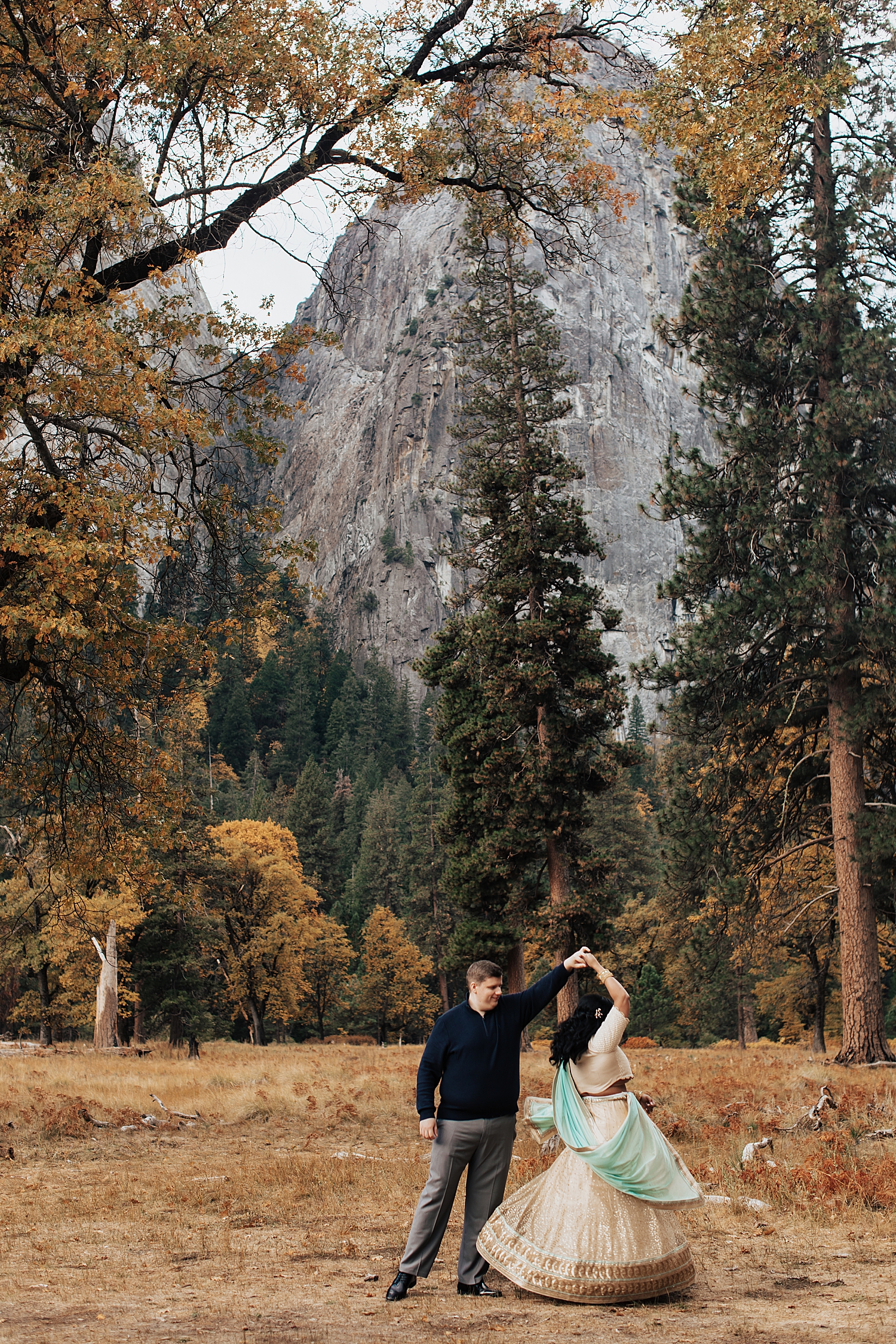 man spins his bride-to-be in Indian dress in field by Destination wedding photographer