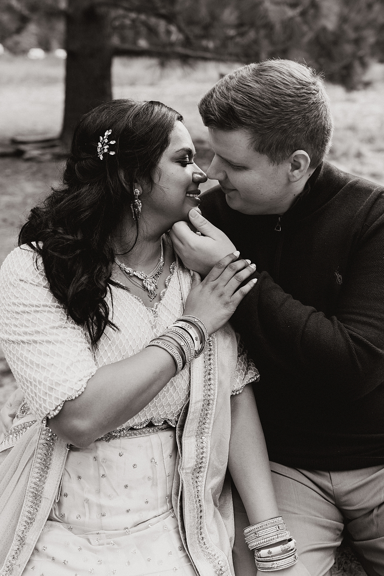 man tips woman's chin towards him for a kiss outside by Destination wedding photographer