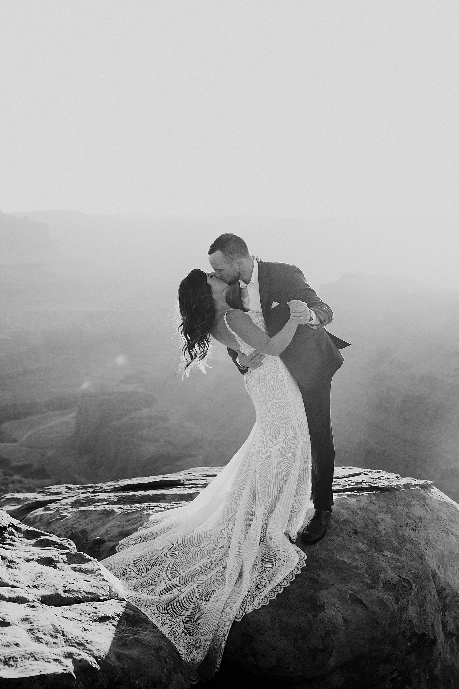 newlyweds share a kiss on cliff by Destination elopement photographer