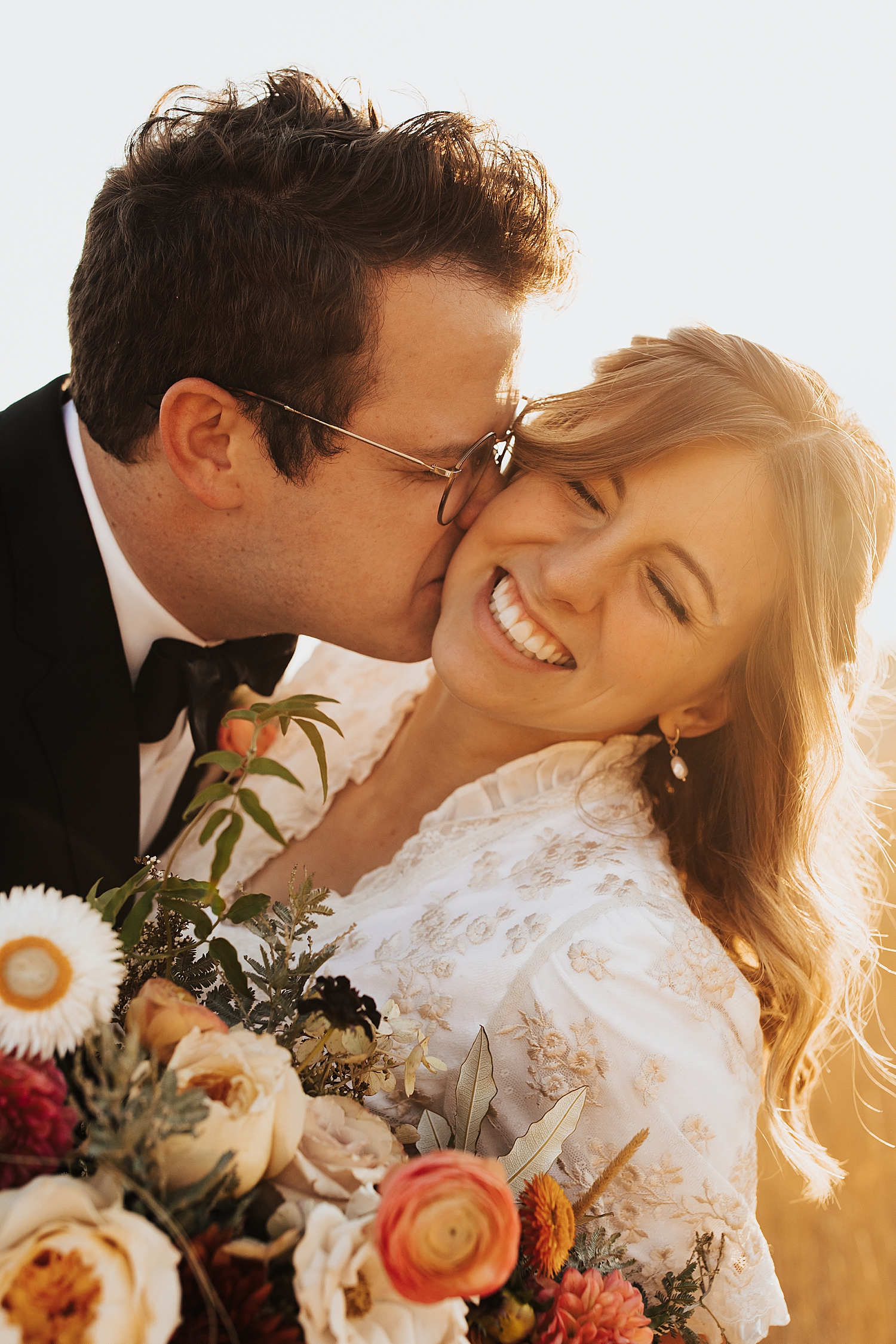groom kisses his bride and she giggles at Tunnel Springs