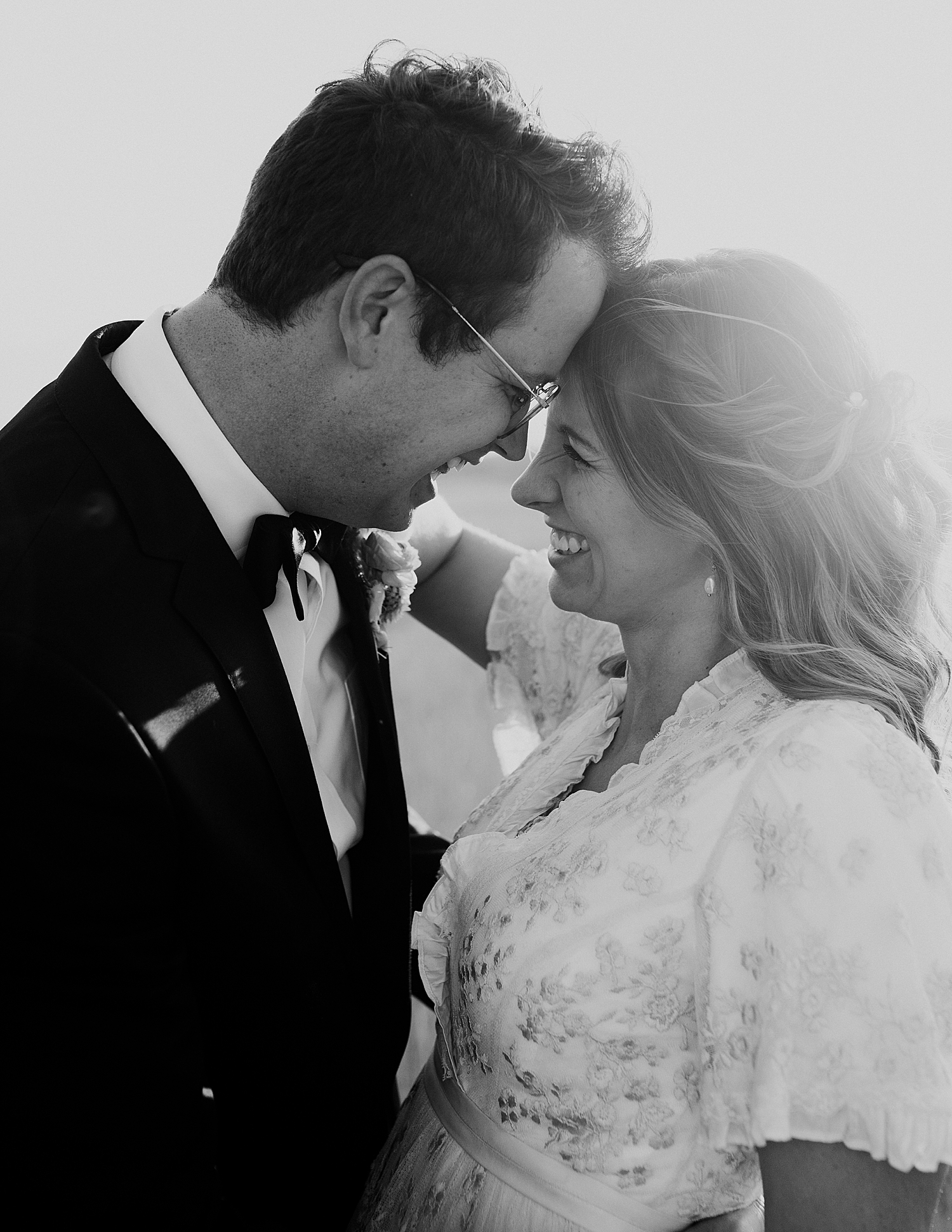 newlyweds embrace in glowing setting sun by Destination wedding photographer
