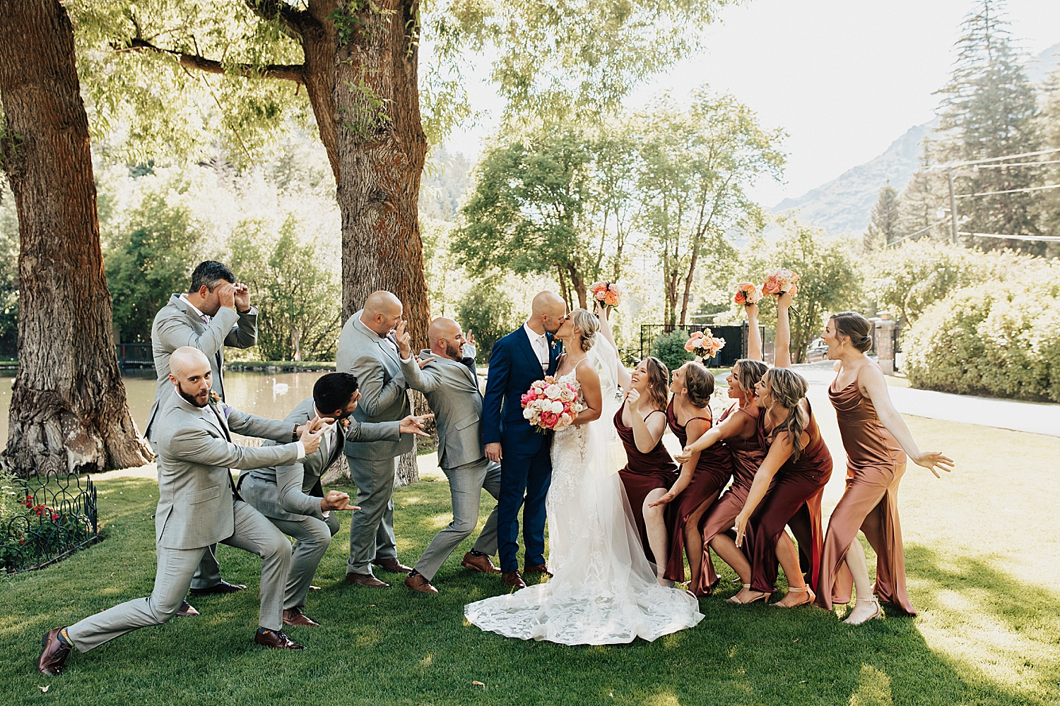 wedding party throws up their arms around bride and groom at Log Haven Venue in Utah