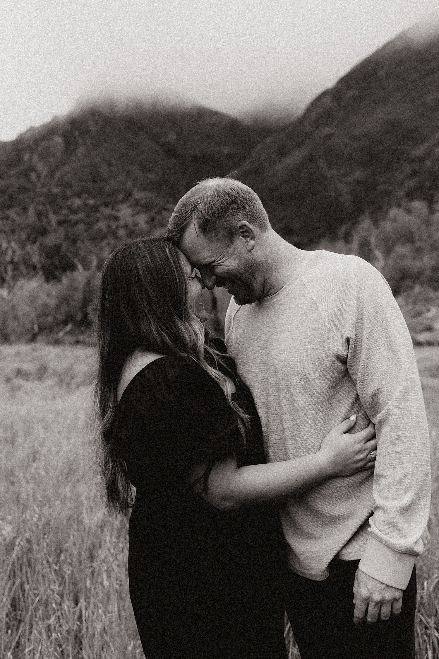 couple puts their foreheads together in a field by Destination wedding photographer
