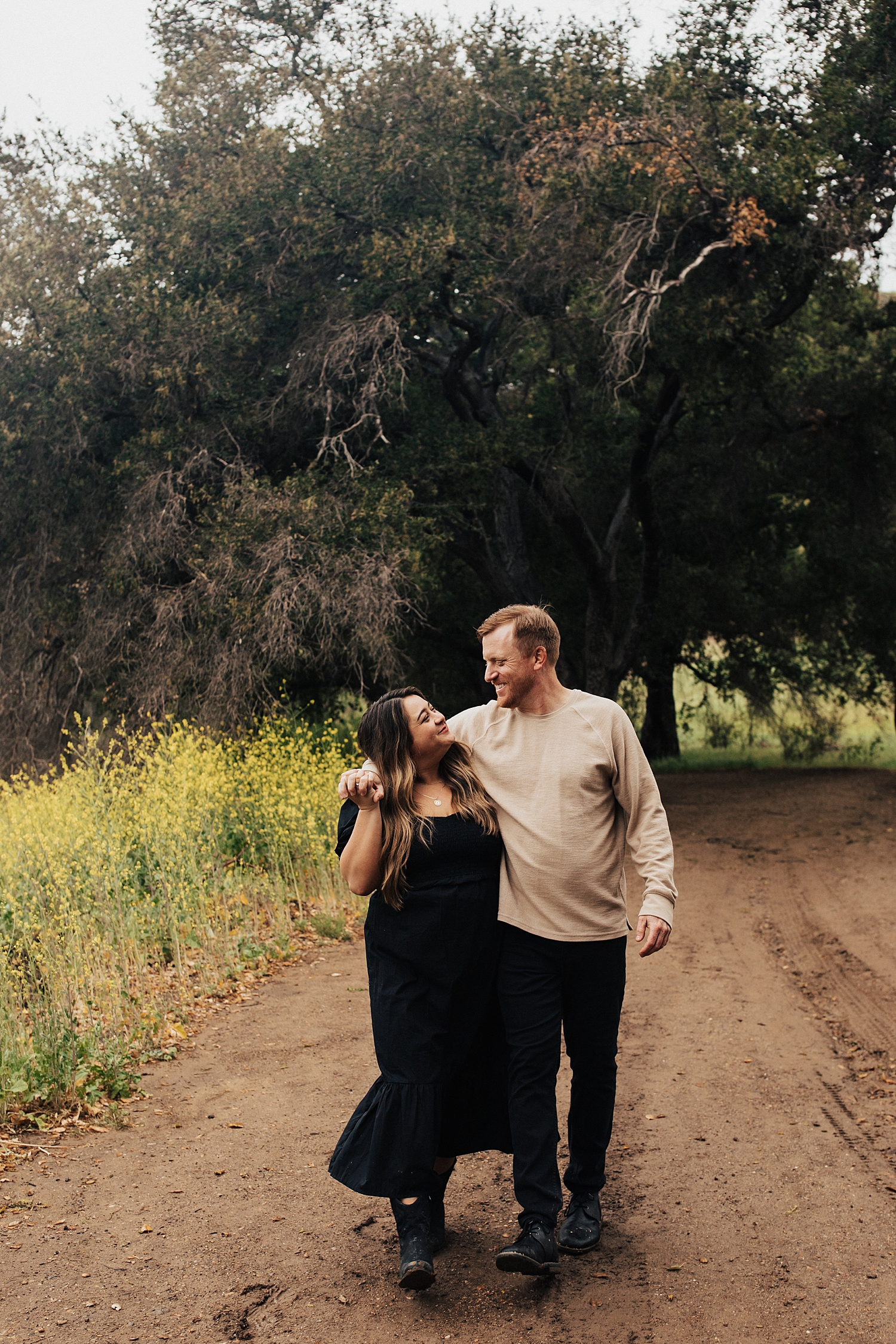 man and woman laugh while walking on path in Malibu Creek State Park