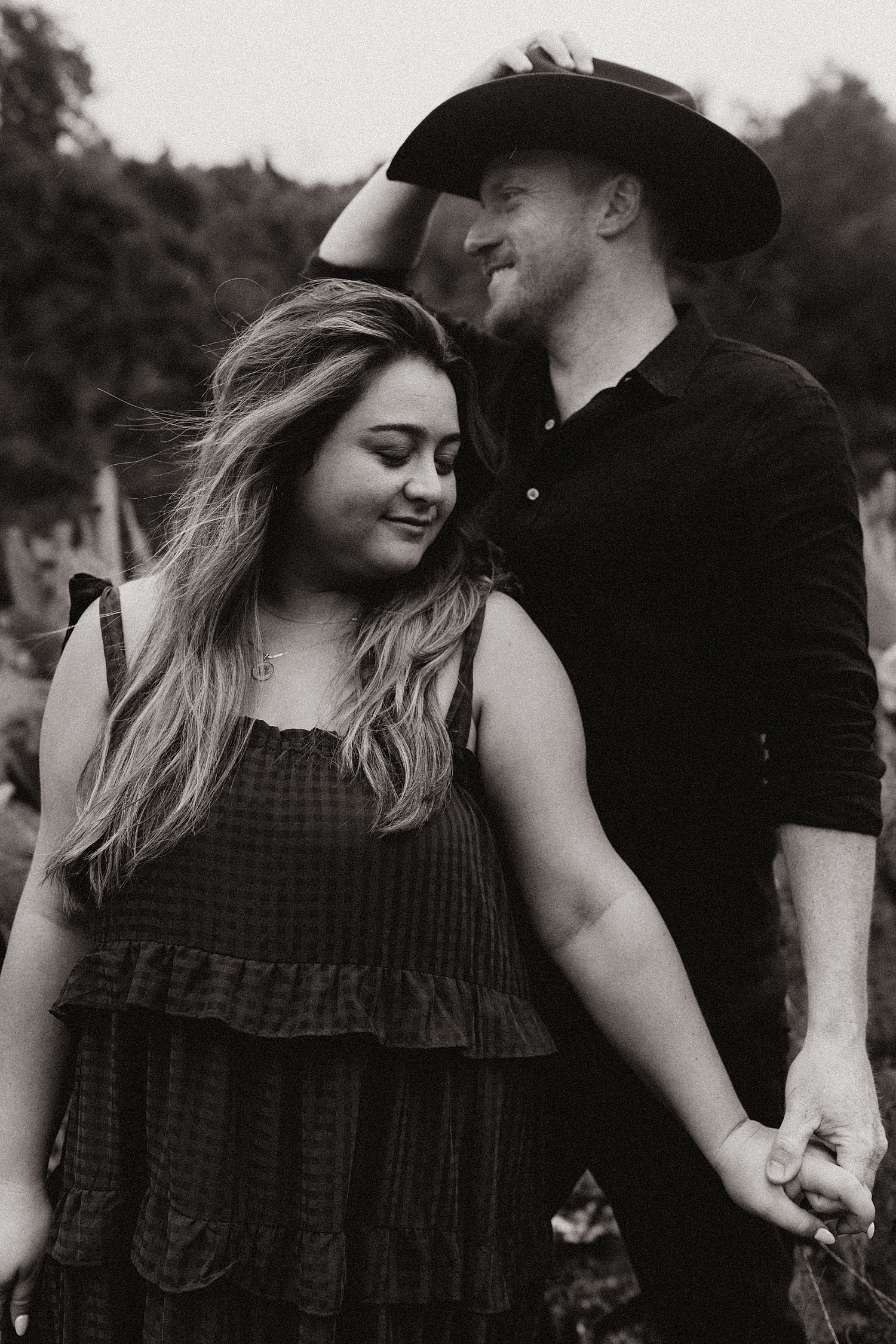 man in hat holds hands with his woman by Nicole Aston Photography