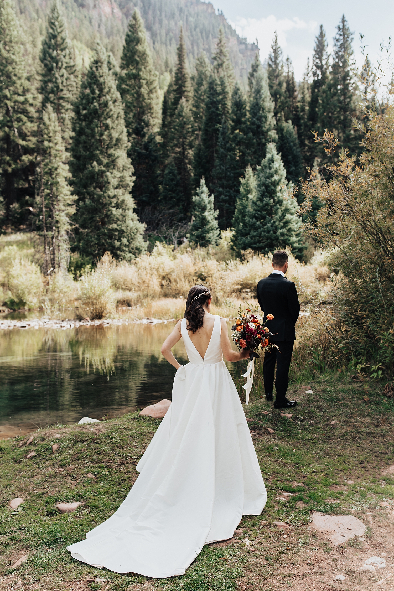 bride approaches her groom for first look outside for summer wedding in aspen