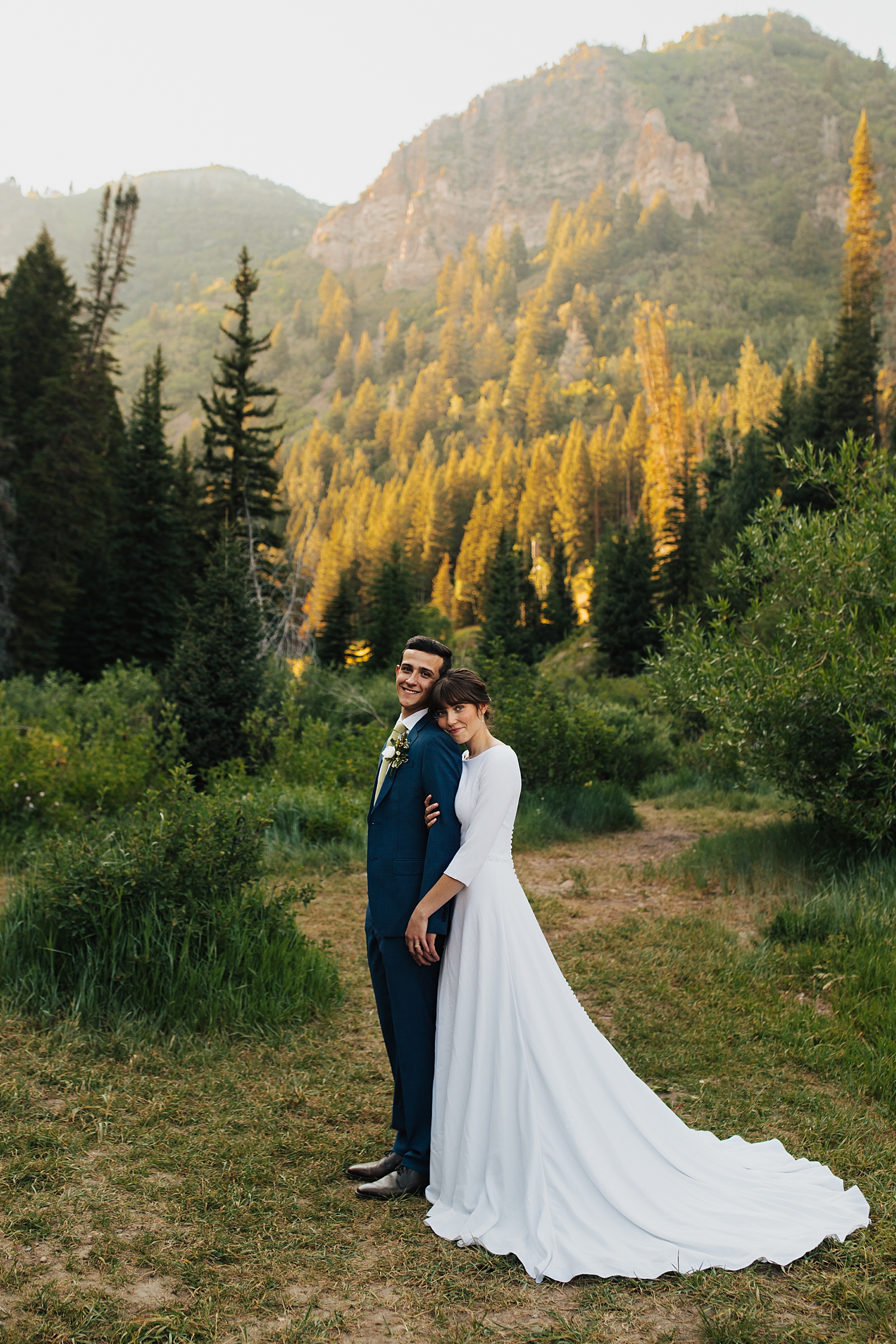 woman leans against her man's back with mountains in the distance by Destination wedding photographer