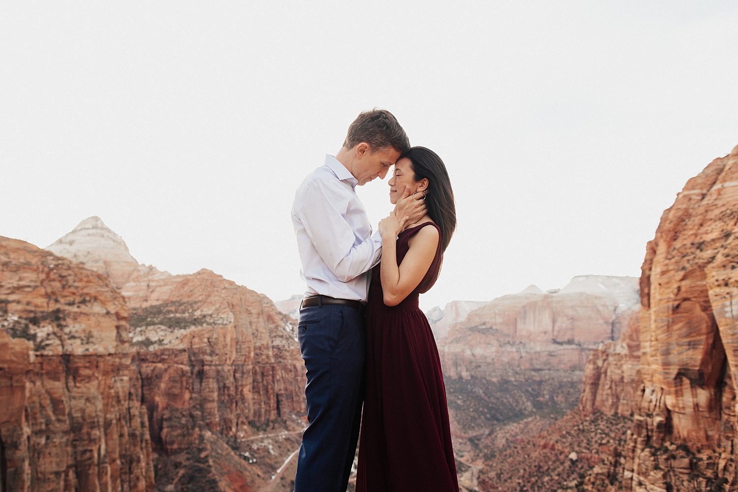 couple stand forehead to forehead with stunning landscape behind by Nicole Aston Photography