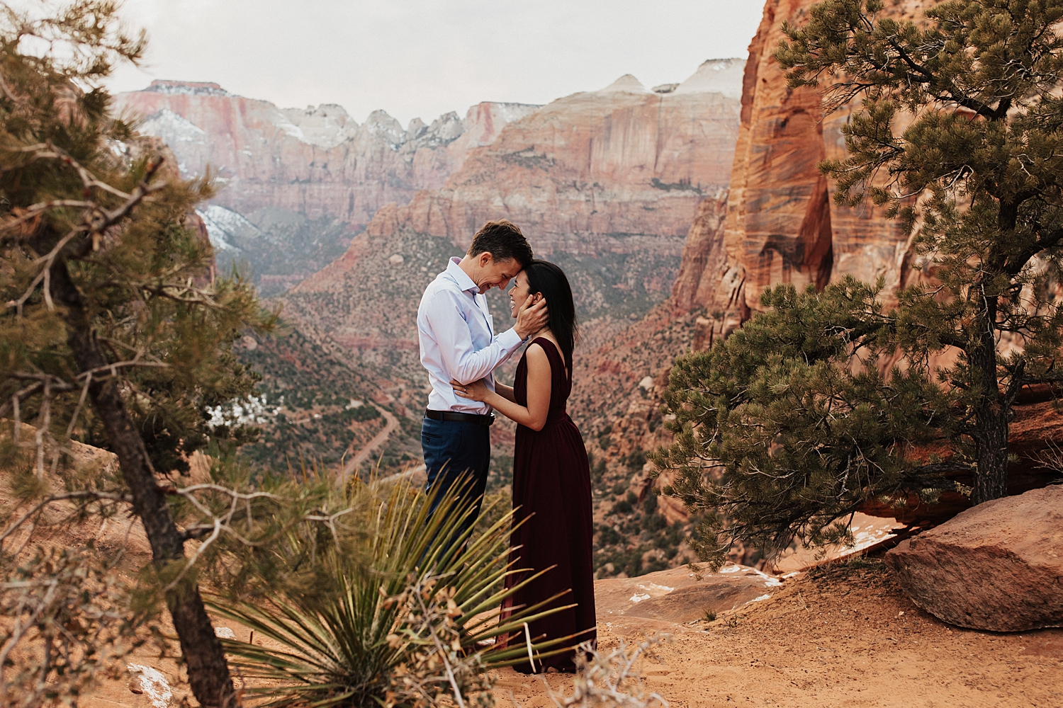 Couple leans their foreheads together in front of mountain backdrop at Zion National Park