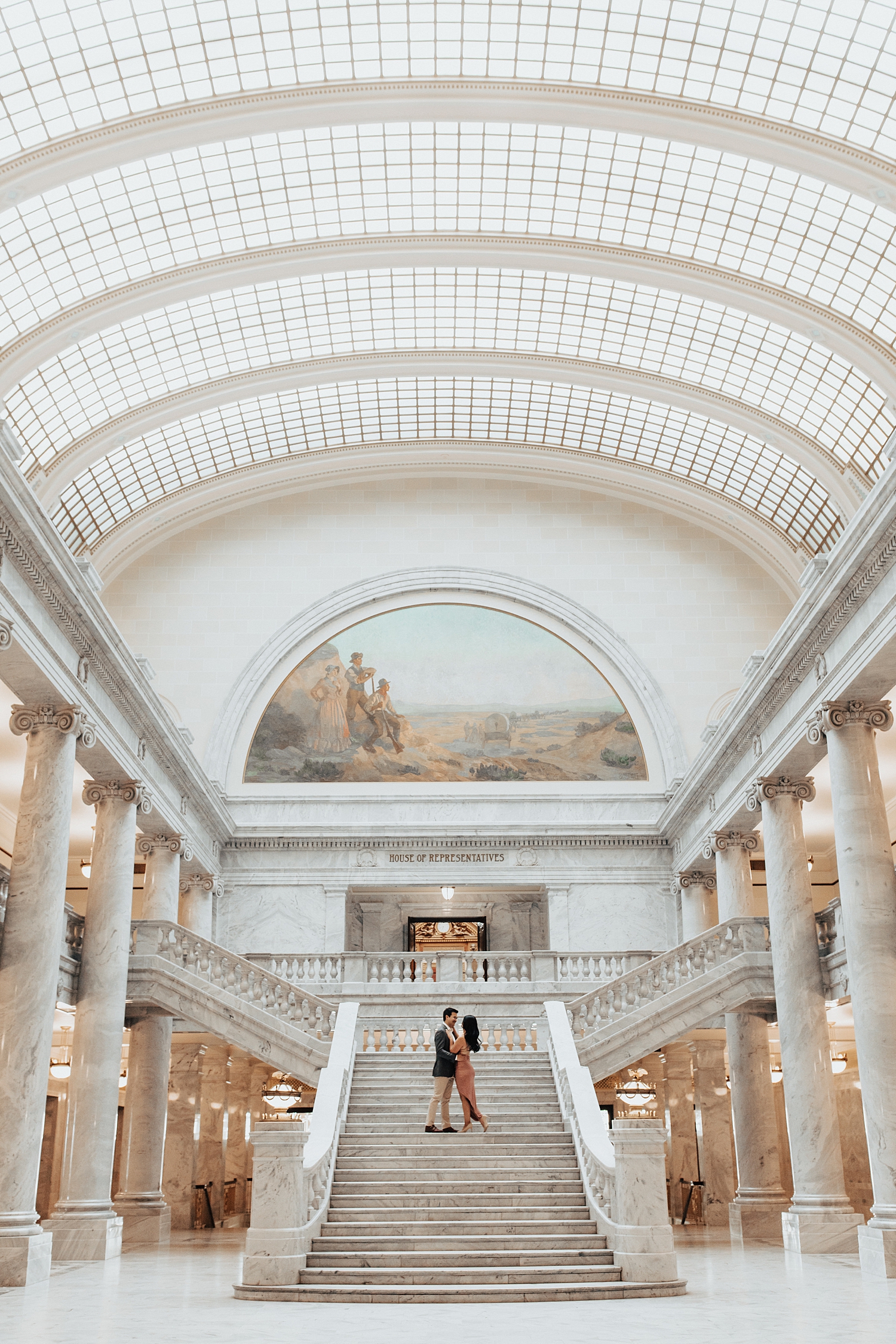couple stands on ornate staircase for Capitol Building engagement session