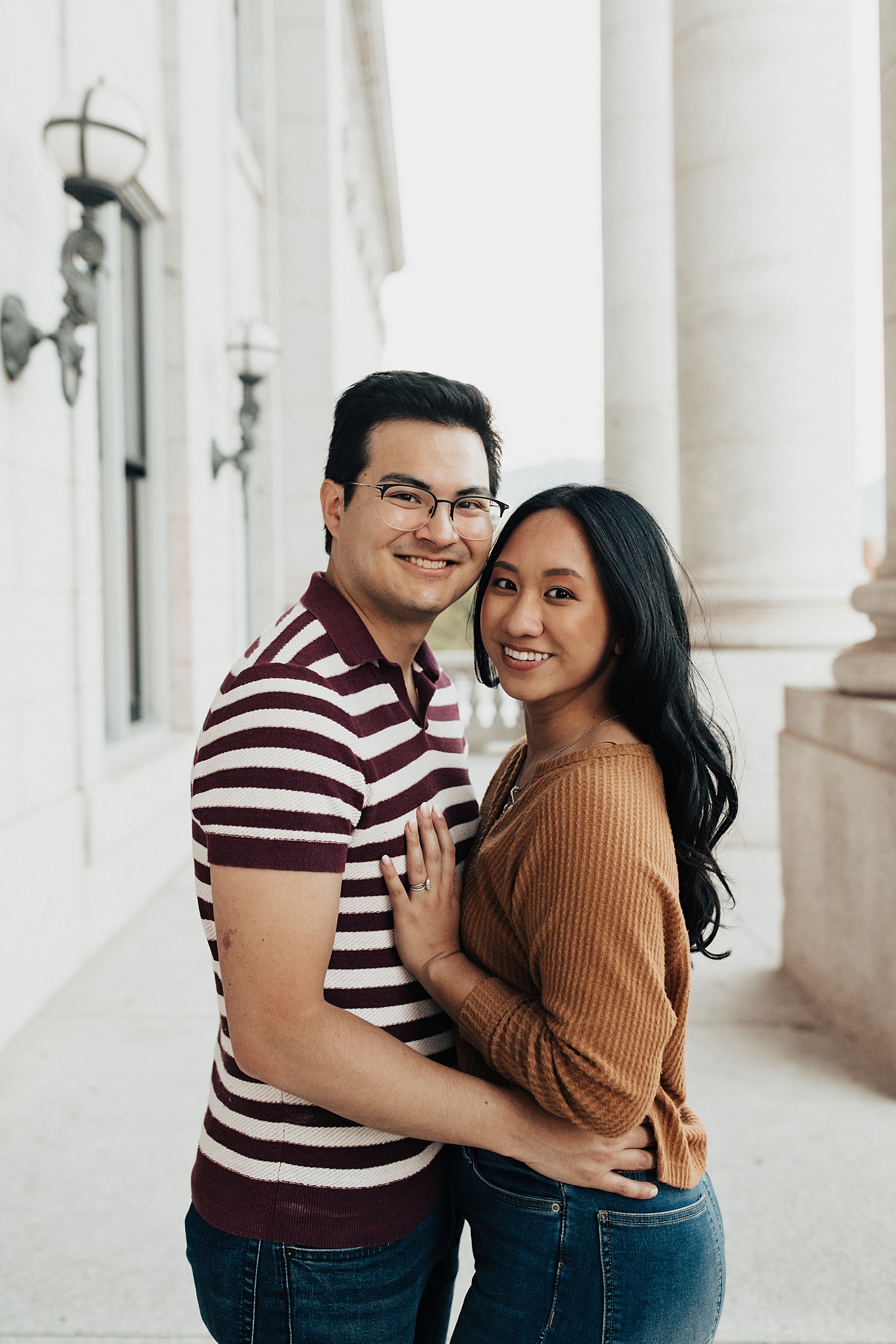 couple stands together outside on balcony by Nicole Aston Photography